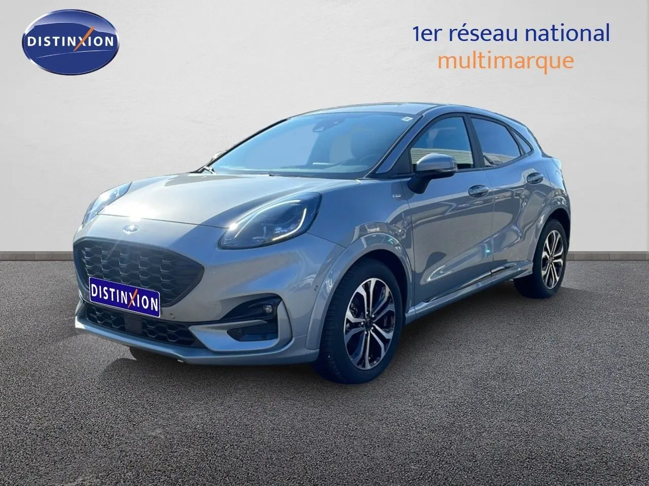 Ford Puma 2023 gris Solar Metal en 3/4 avant droit, finition ST-LINE X avec jantes alliage et calandre noire.
