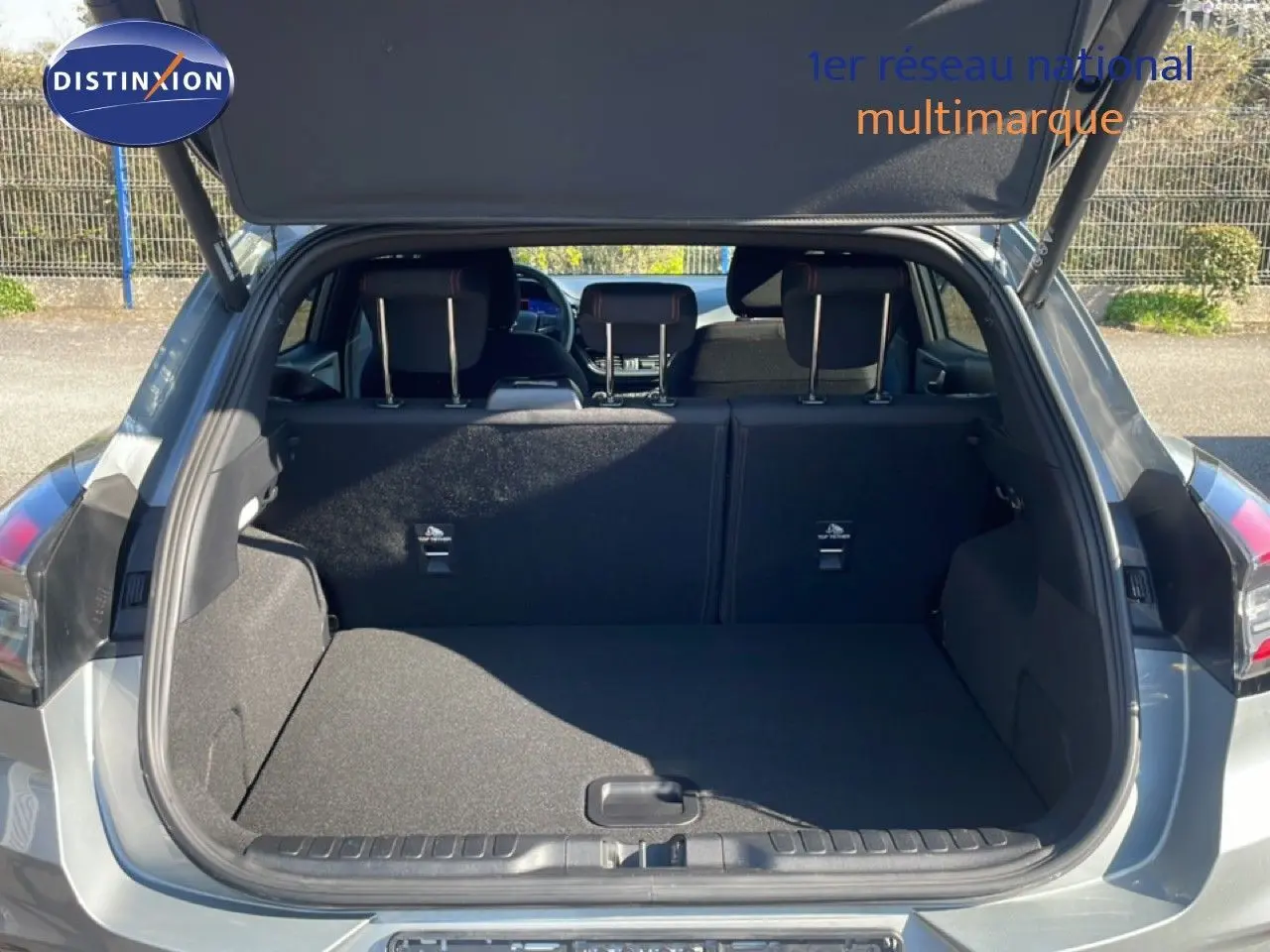 Coffre ouvert vu de l'arrière d'un Ford Puma gris Solar Metal, montrant l'espace de chargement et les dossiers de sièges arrière.