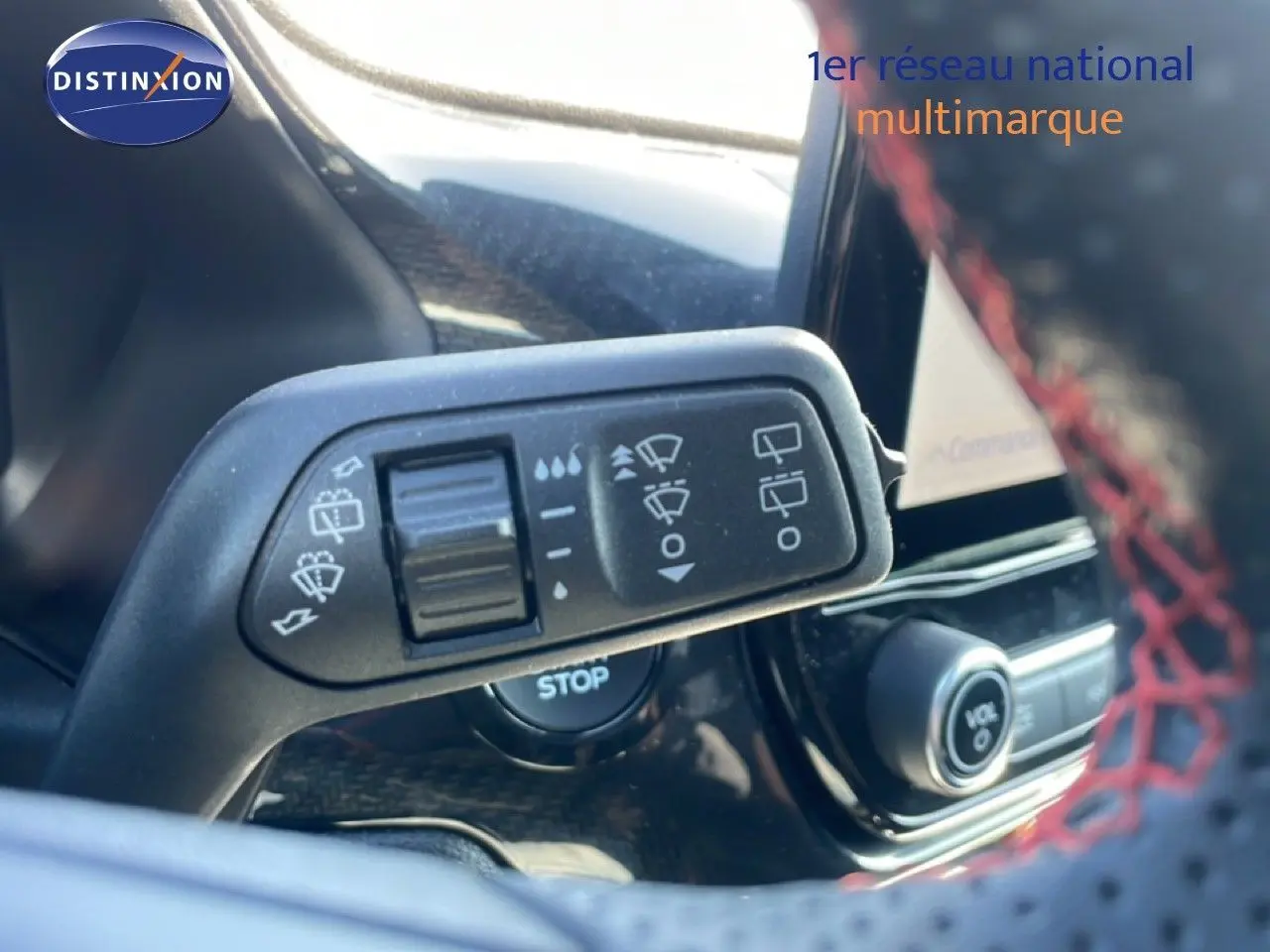 Gros plan sur la commande d’essuie-glace à gauche du volant dans l’habitacle du Ford Puma gris Solar Metal 2023.