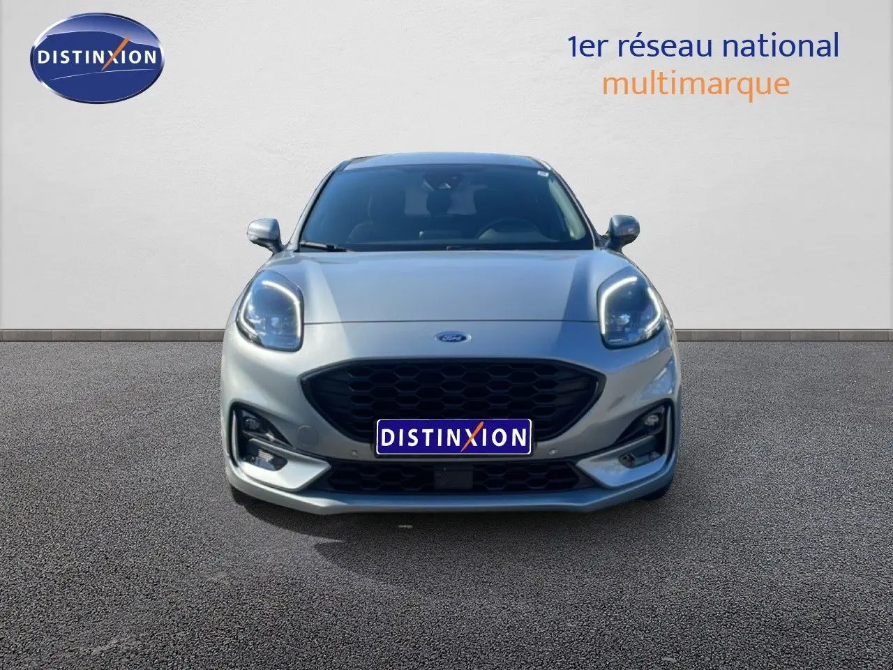 Vue frontale d'un Ford Puma gris Solar Metal 2023 avec calandre noire et phares LED allumés.