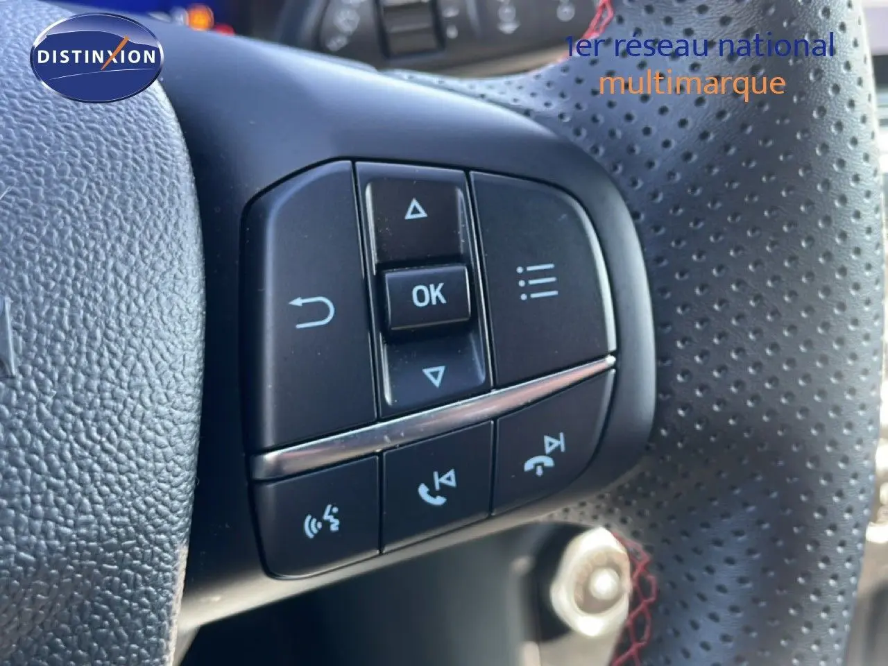 Gros plan sur les commandes multifonctions du volant perforé d’un Ford Puma gris Solar Metal, version 2023.