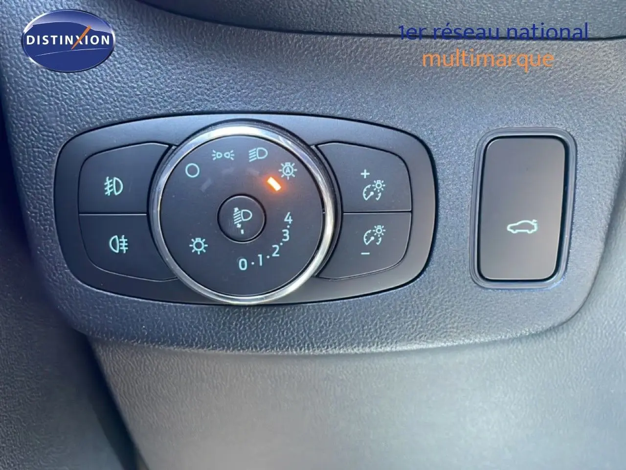 Gros plan sur les commandes d’éclairage et ouverture du coffre du Ford Puma 2023, intérieur noir texturé.