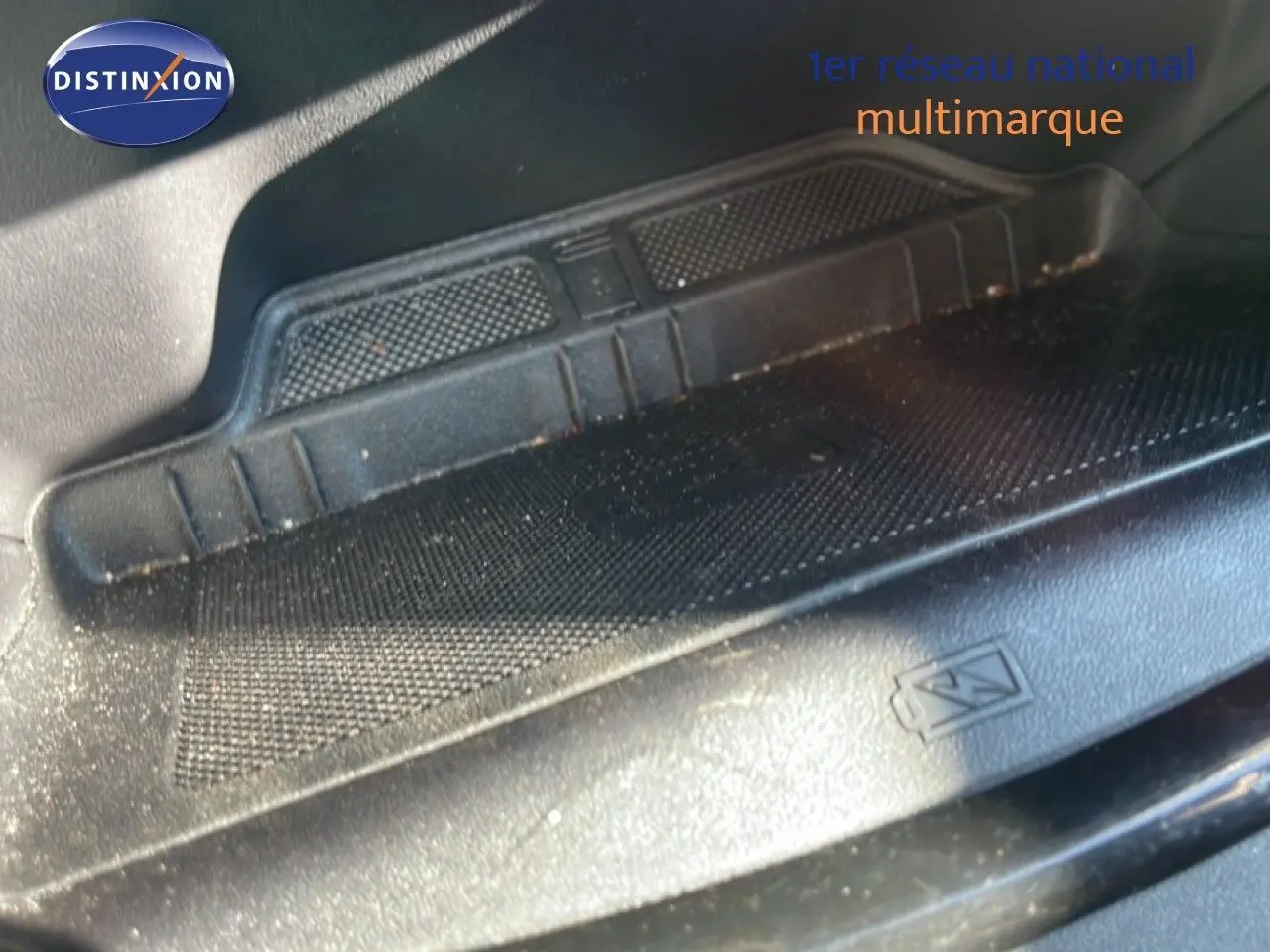 Détail du tapis de sol noir avec symbole de recharge sans fil dans un Ford Puma gris Solar Metal 2023.