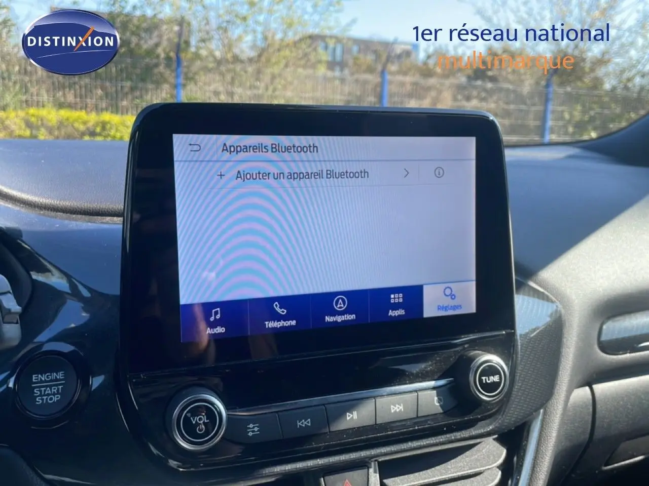 Vue rapprochée de l’écran tactile central du Ford Puma gris Solar Metal, affichant le menu Bluetooth en extérieur.