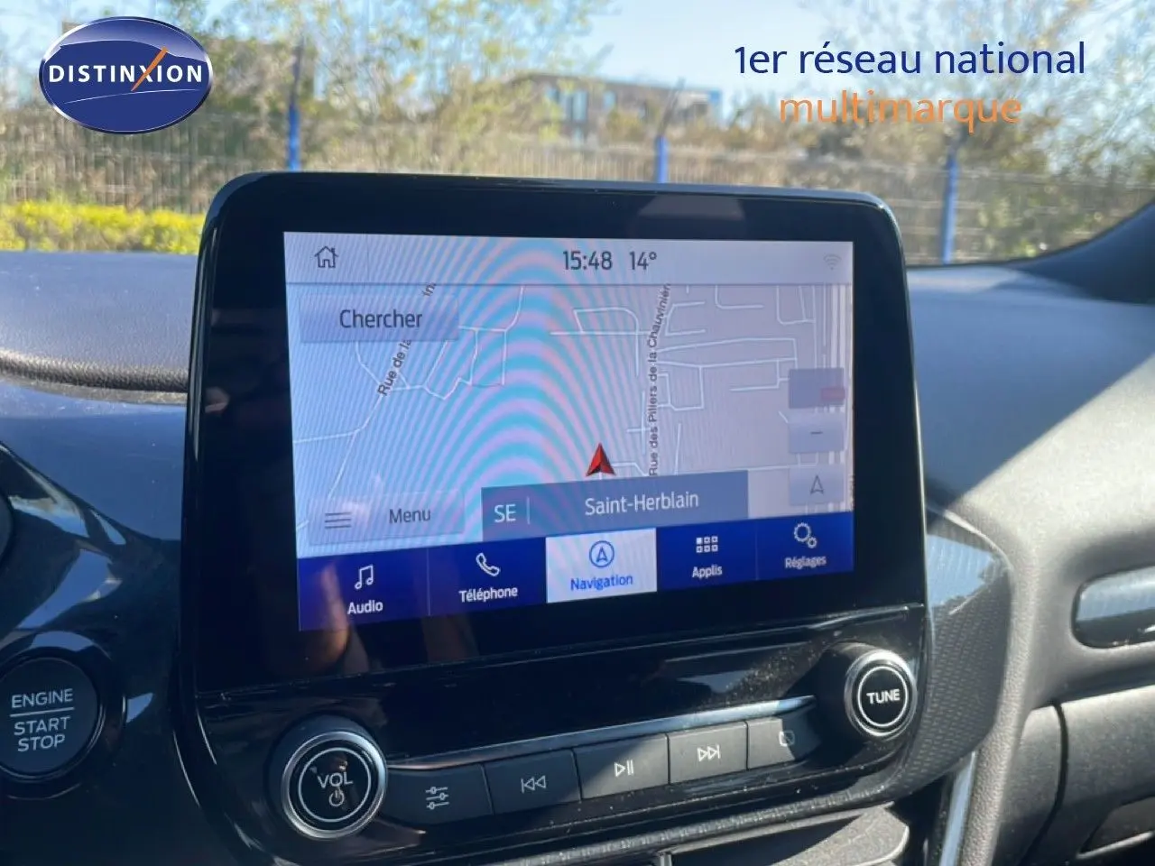 Vue rapprochée de l’écran tactile central du Ford Puma gris Solar Metal, affichant la navigation GPS sur fond extérieur lumineux.
