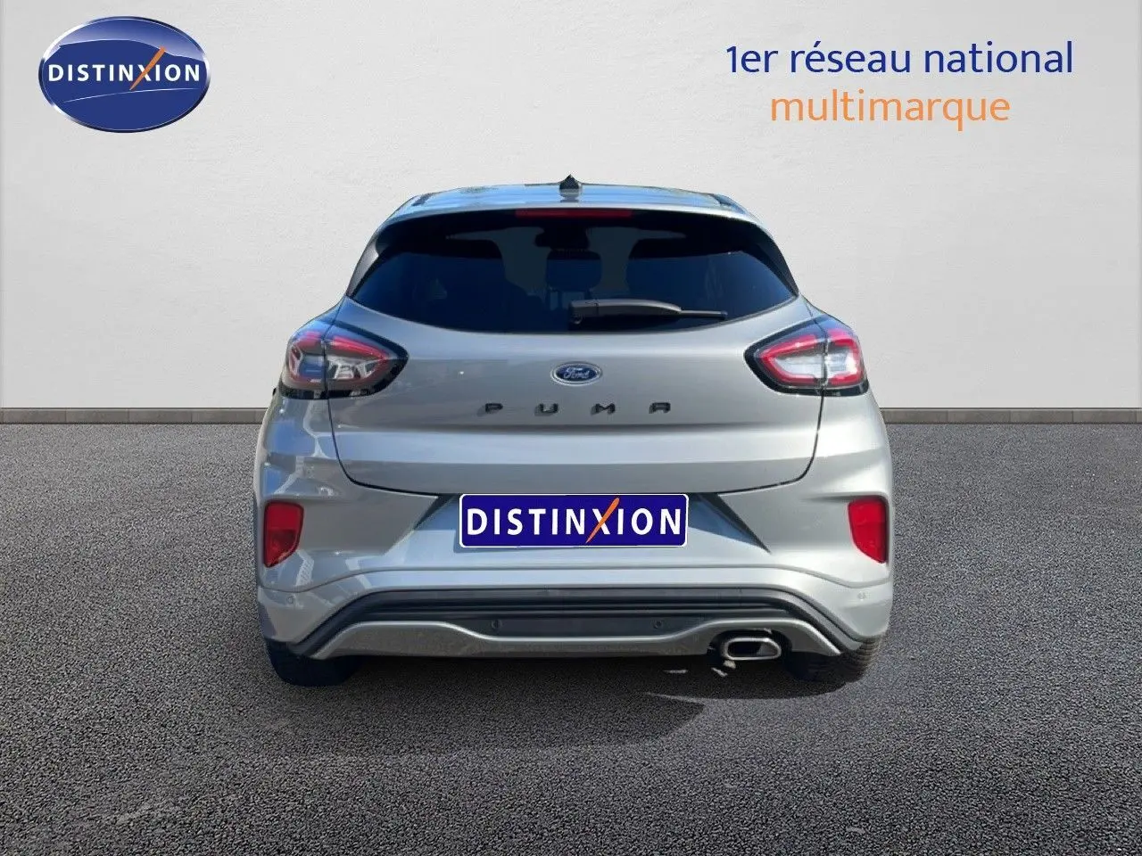 Vue arrière d'un Ford Puma gris Solar Metal 2023 avec feux distinctifs et sortie d'échappement chromée côté droit.