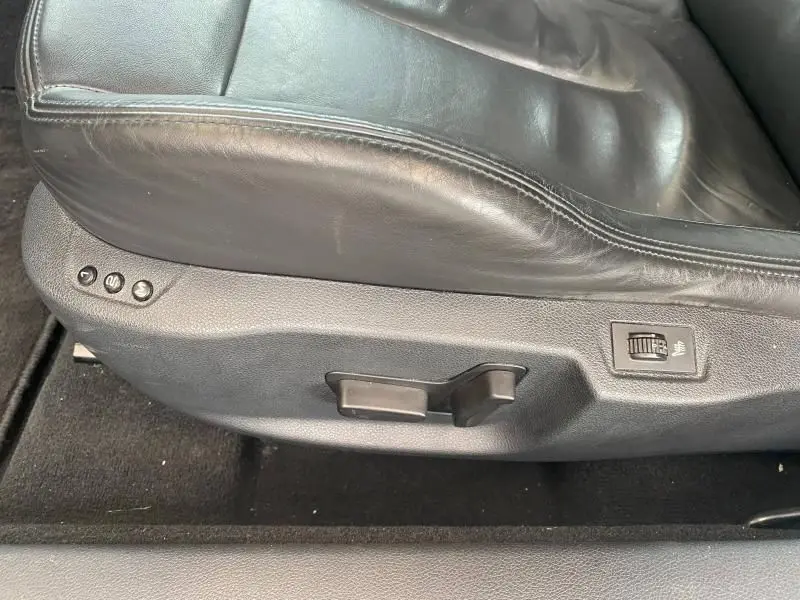 Gros plan sur le siège avant en cuir noir du Peugeot RCZ 2010, montrant les commandes électriques et le réglage de chauffage.