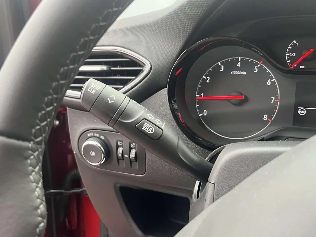 Gros plan sur le commodo de clignotant et le compte-tours du tableau de bord d'une Opel Crossland rouge de 2022.