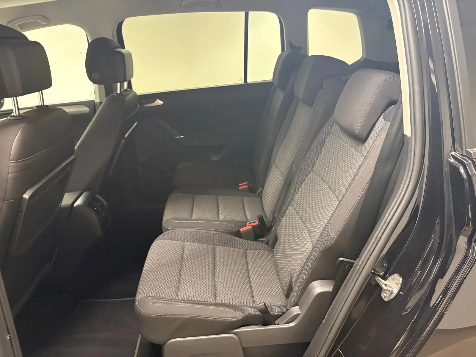 Vue intérieure côté droit sur la banquette arrière en tissu gris du Volkswagen Touran Noir Intense 2024.