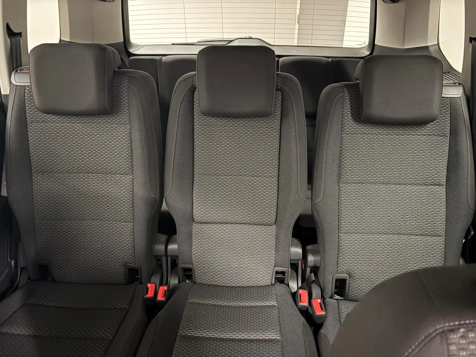 Vue intérieure centrée sur les trois sièges arrière noirs du Volkswagen Touran 2024, finition Life Plus.