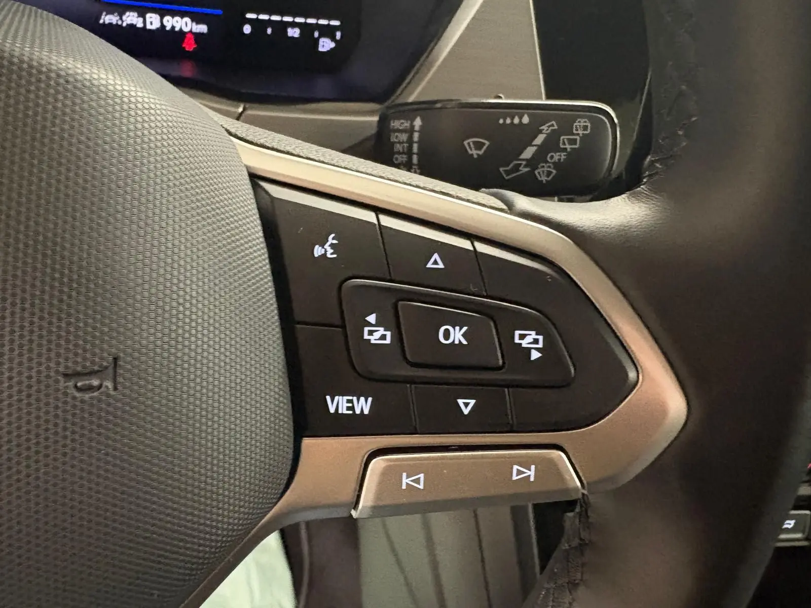 Gros plan sur les commandes multifonctions à droite du volant du Volkswagen Touran 2024 noir intense nacré.