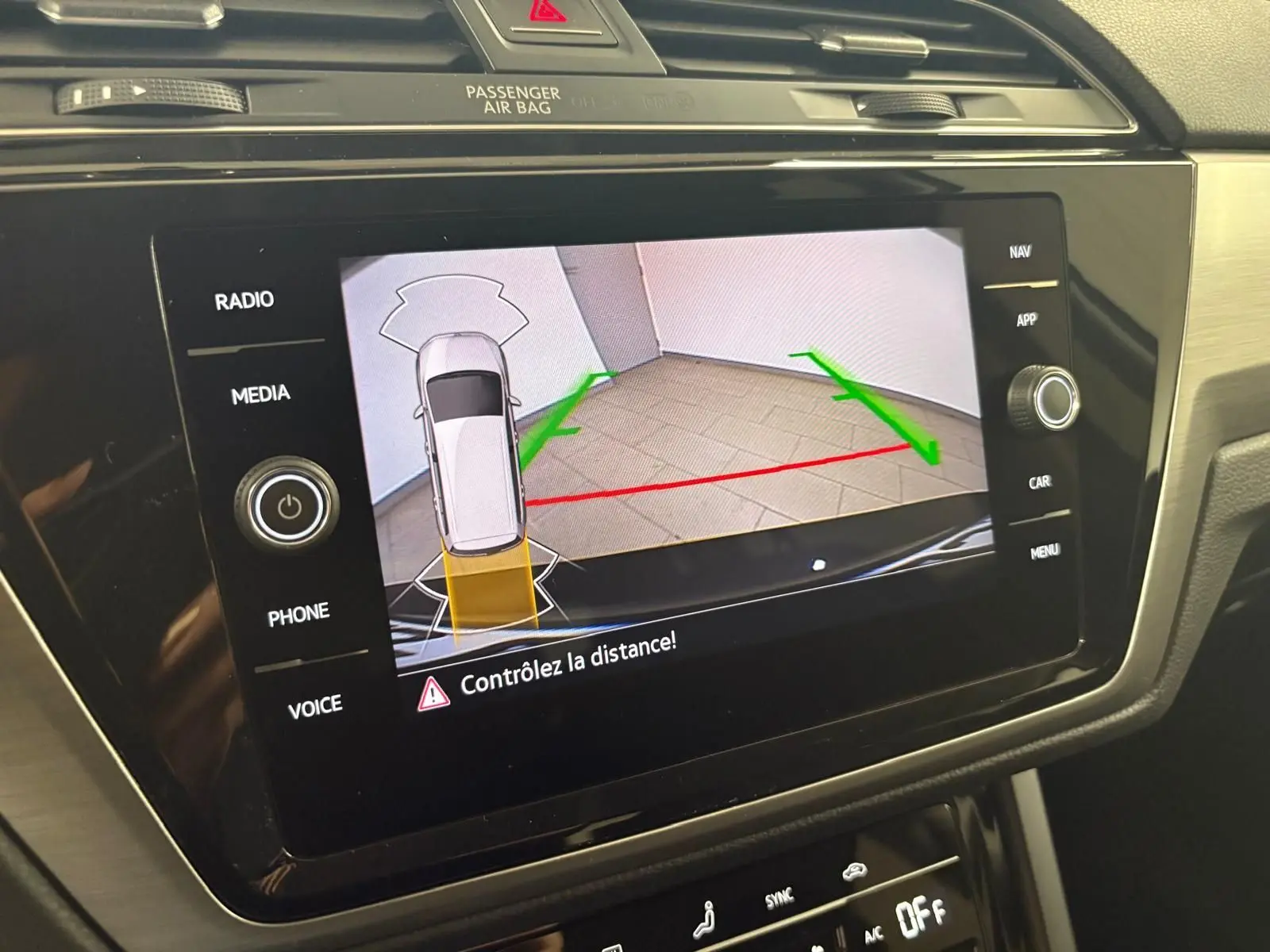 Écran central du Volkswagen Touran 2024 affichant la caméra de recul avec guidage de trajectoire en intérieur noir nacré.