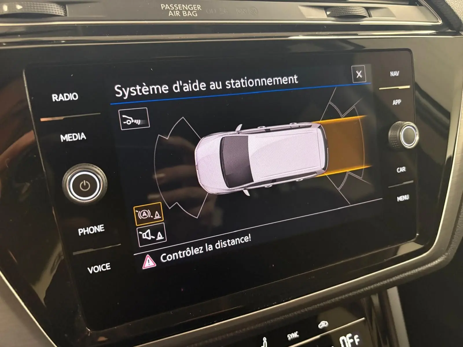 Écran tactile du système d'aide au stationnement dans l'habitacle du Volkswagen Touran noir intense nacré.