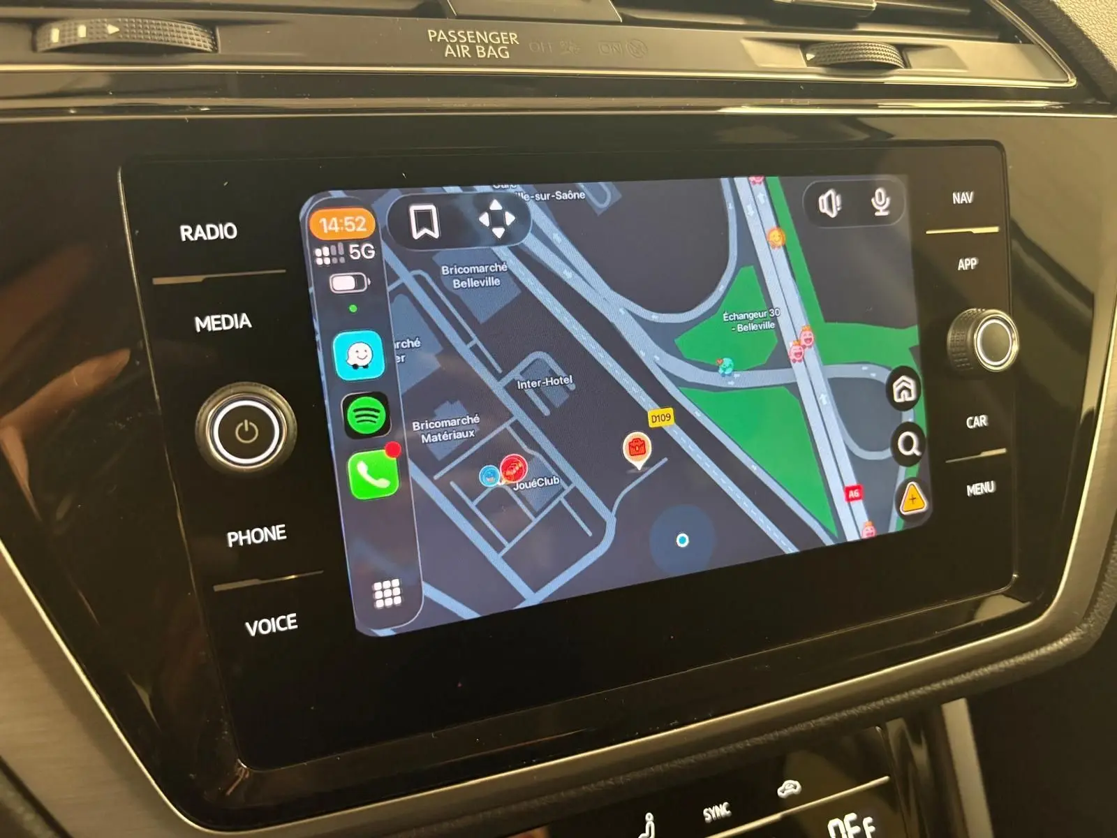 Écran tactile central du Volkswagen Touran 2024 affichant la navigation avec interface connectée, ambiance intérieure noire.