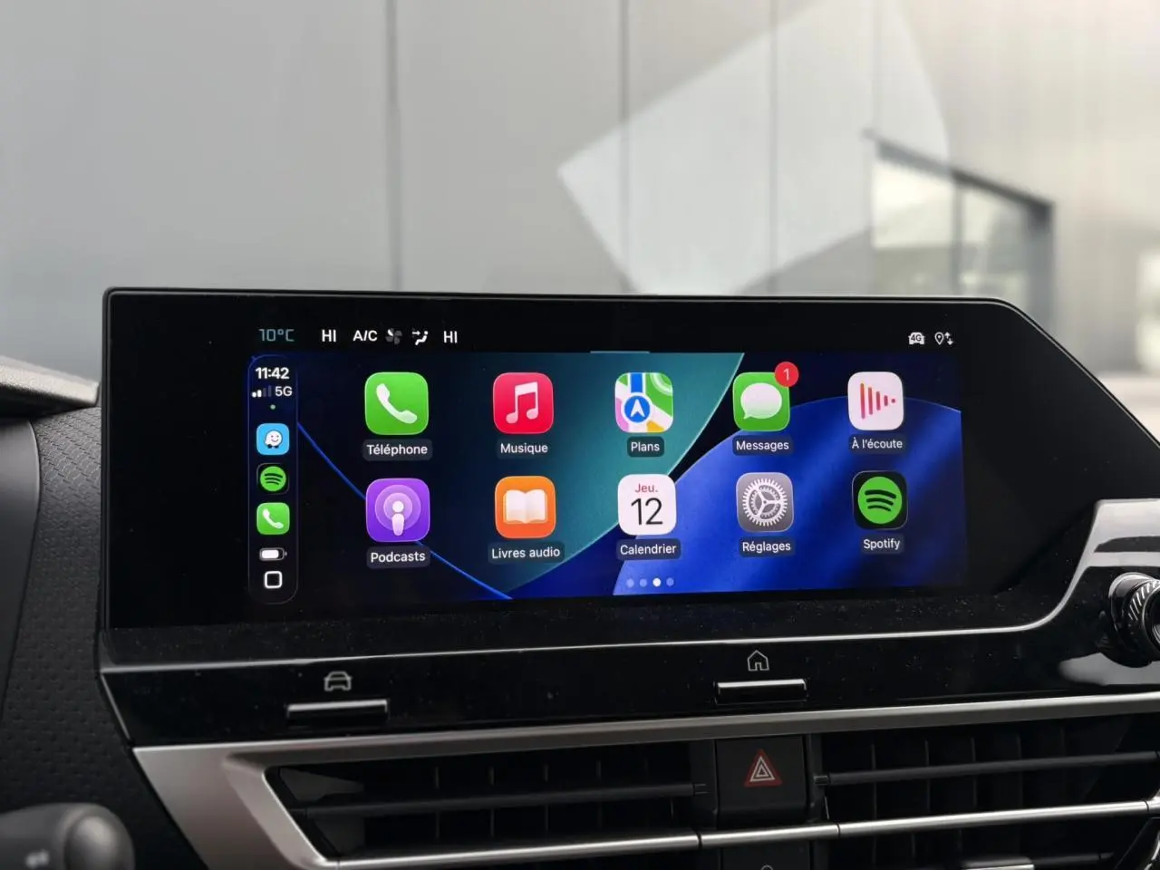 Écran tactile central affichant Apple CarPlay dans l'habitacle du Citroën C4 Hybrid gris Mercury, vue de face.
