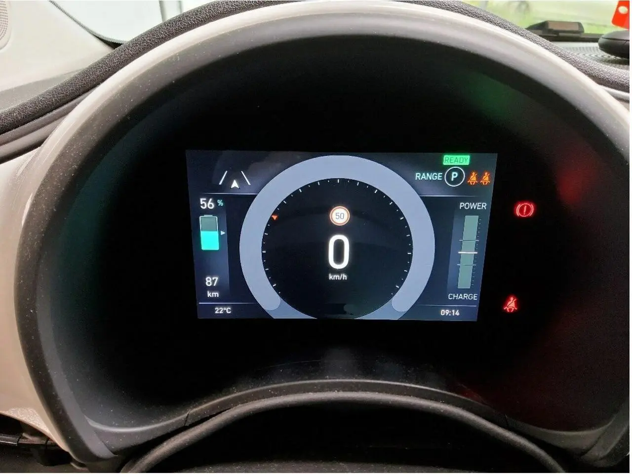 Gros plan sur l'avant droit blanc de la Fiat 500 électrique 2024, mettant en valeur le phare rond et la jante stylisée.