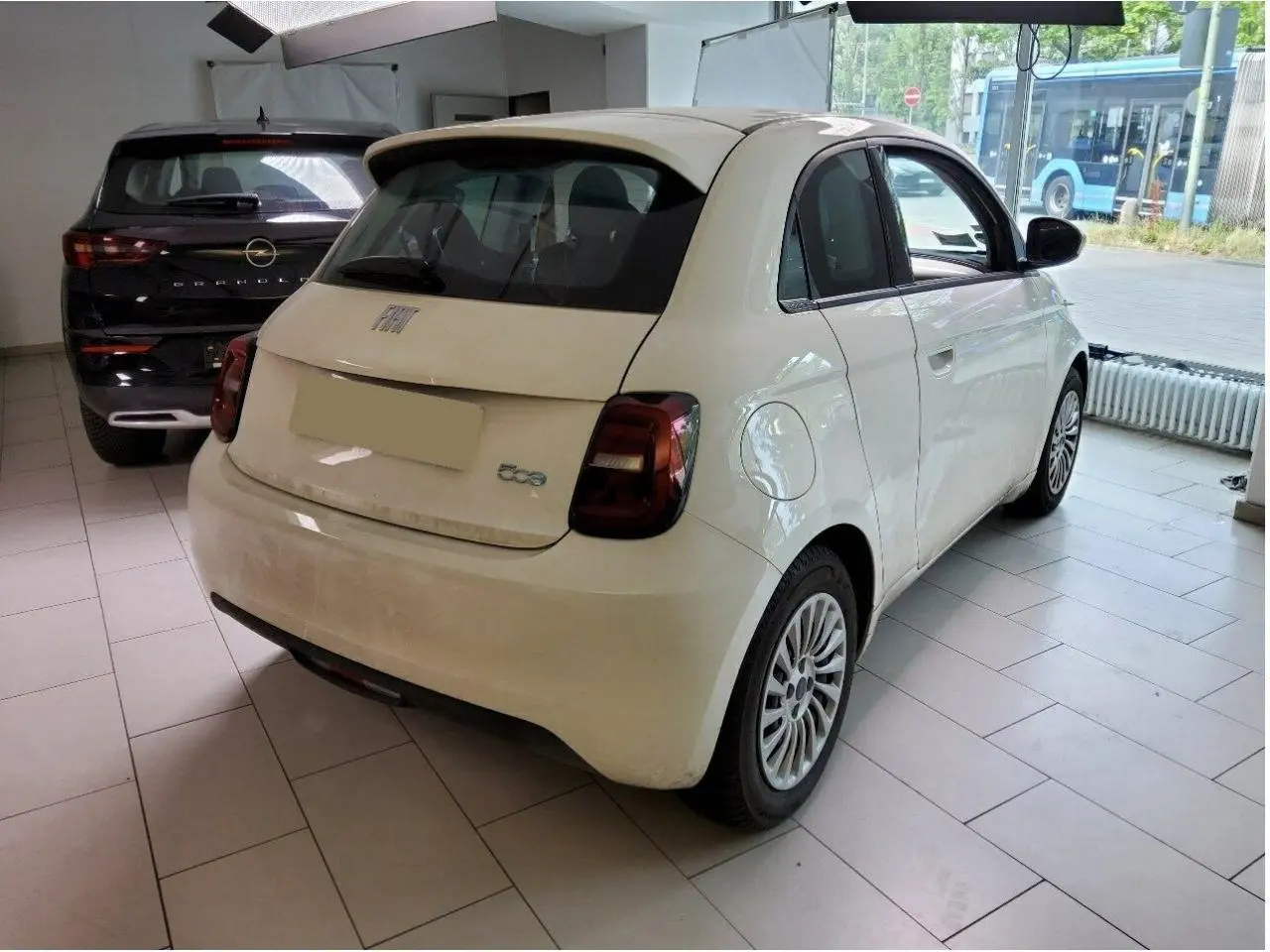 Vue intérieure côté droit de la Fiat 500 électrique 2024, sièges noirs avec surpiqûres blanches et tableau de bord moderne.