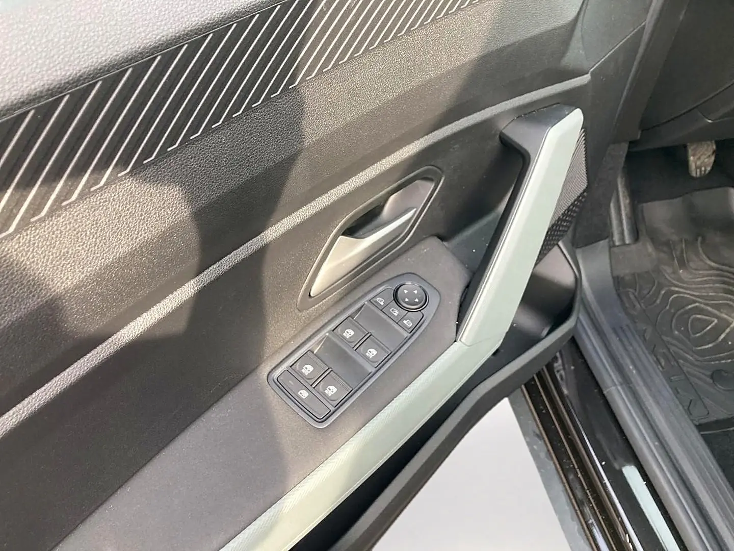 Détail de la porte avant gauche noire du Dacia Bigster 2025 avec commandes électriques des vitres et poignée intégrée.