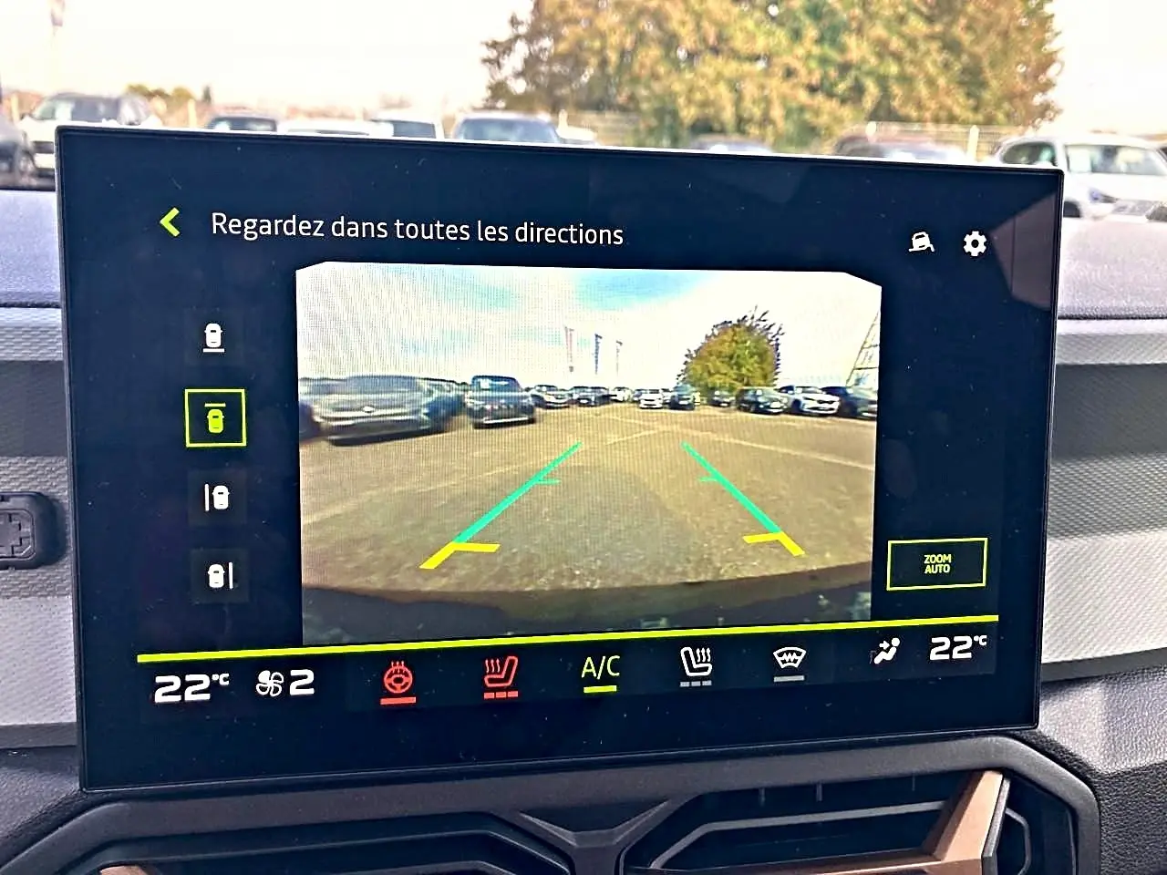Écran tactile intérieur montrant la caméra de recul du Dacia Bigster noir, avec vue arrière sur un parking.