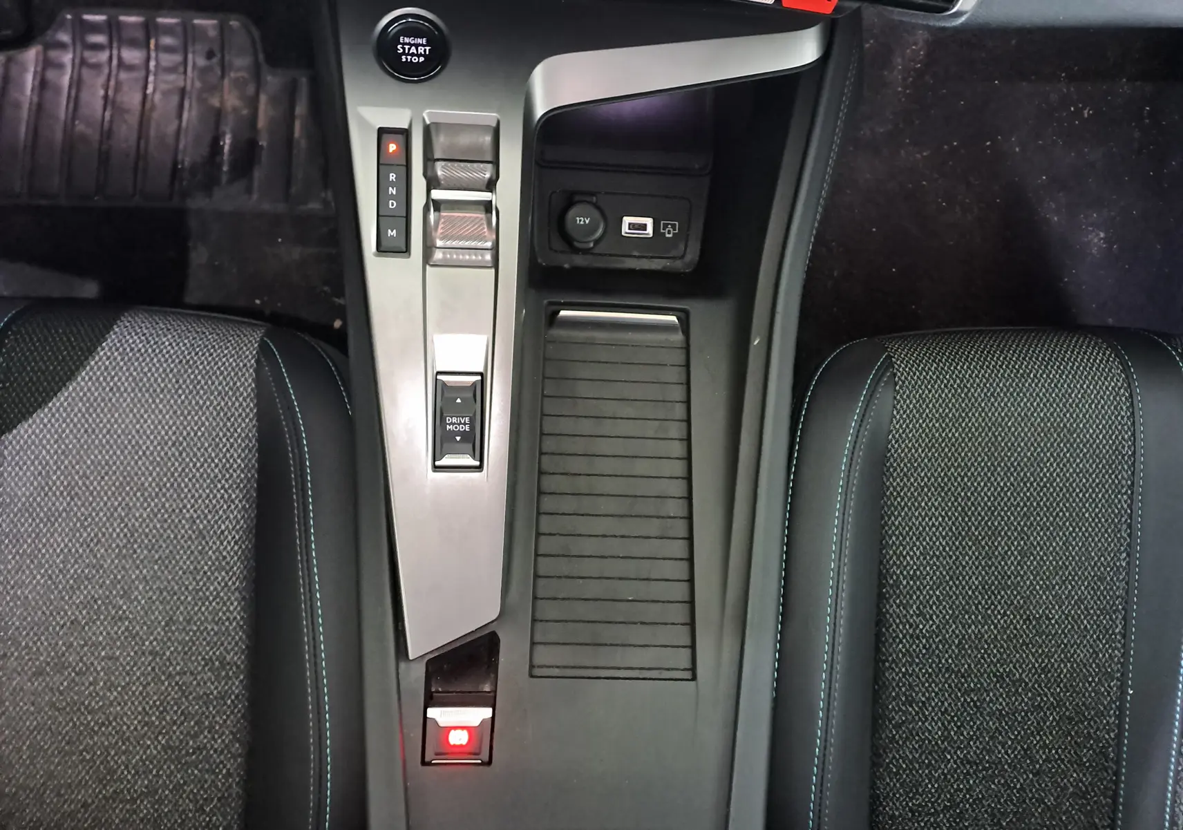 Vue plongeante sur la console centrale de la Peugeot 308 blanche, avec levier de vitesse automatique et sièges noirs tissu.