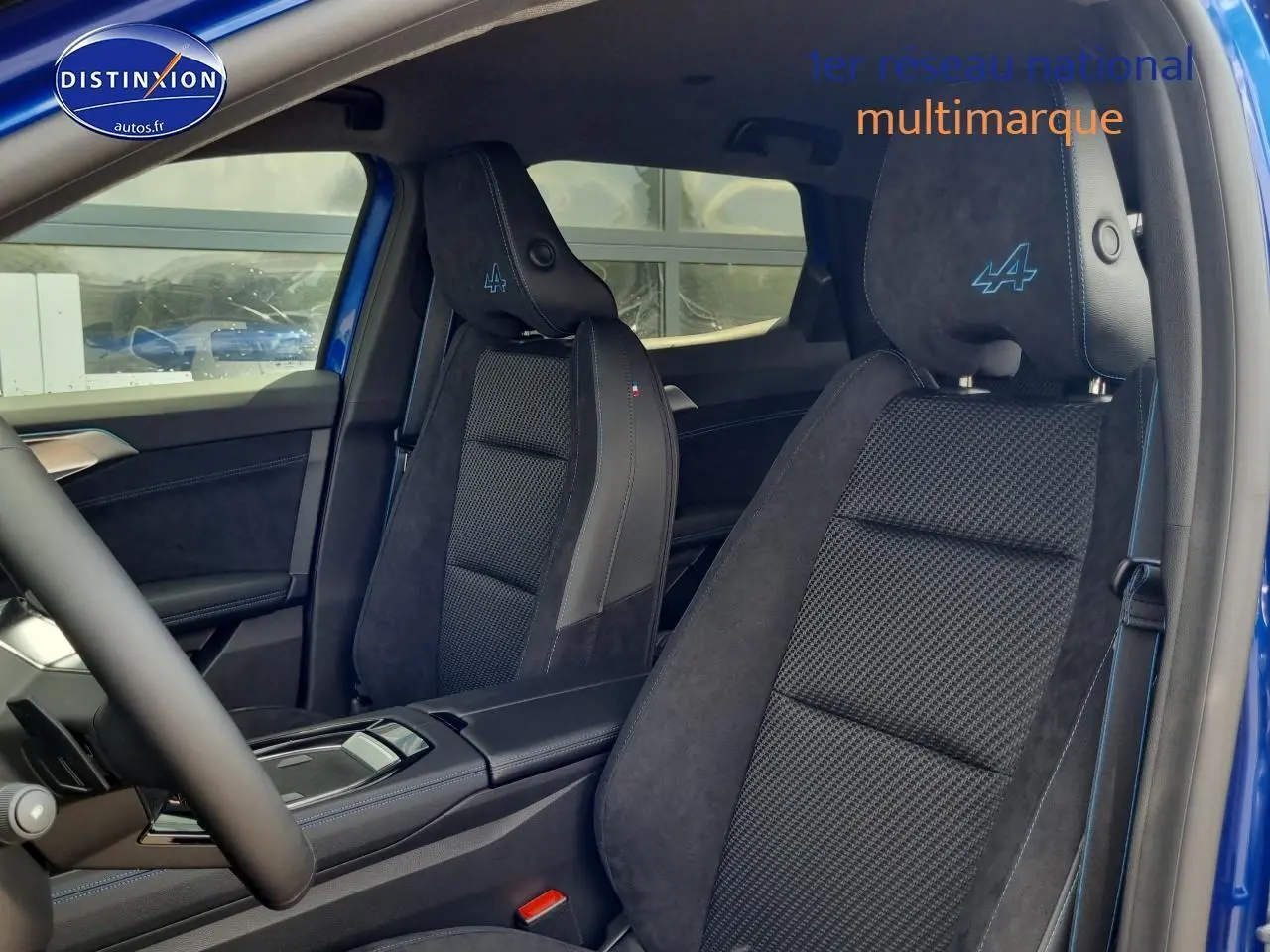 Intérieur du Renault Austral 2025 bleu iron, vue côté conducteur sur sièges sport avec logo Alpine brodé en bleu.