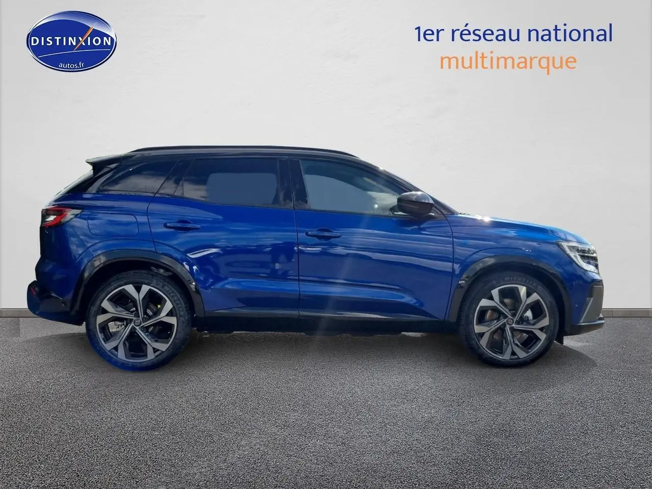 Profil côté gauche du Renault Austral 2025 bleu iron avec jantes alu et toit noir contrasté sur fond clair.