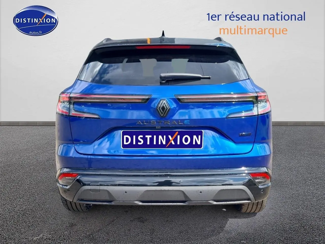 Vue arrière d'un Renault Austral bleu iron avec feux LED étirés et hayon motorisé, sur fond neutre.