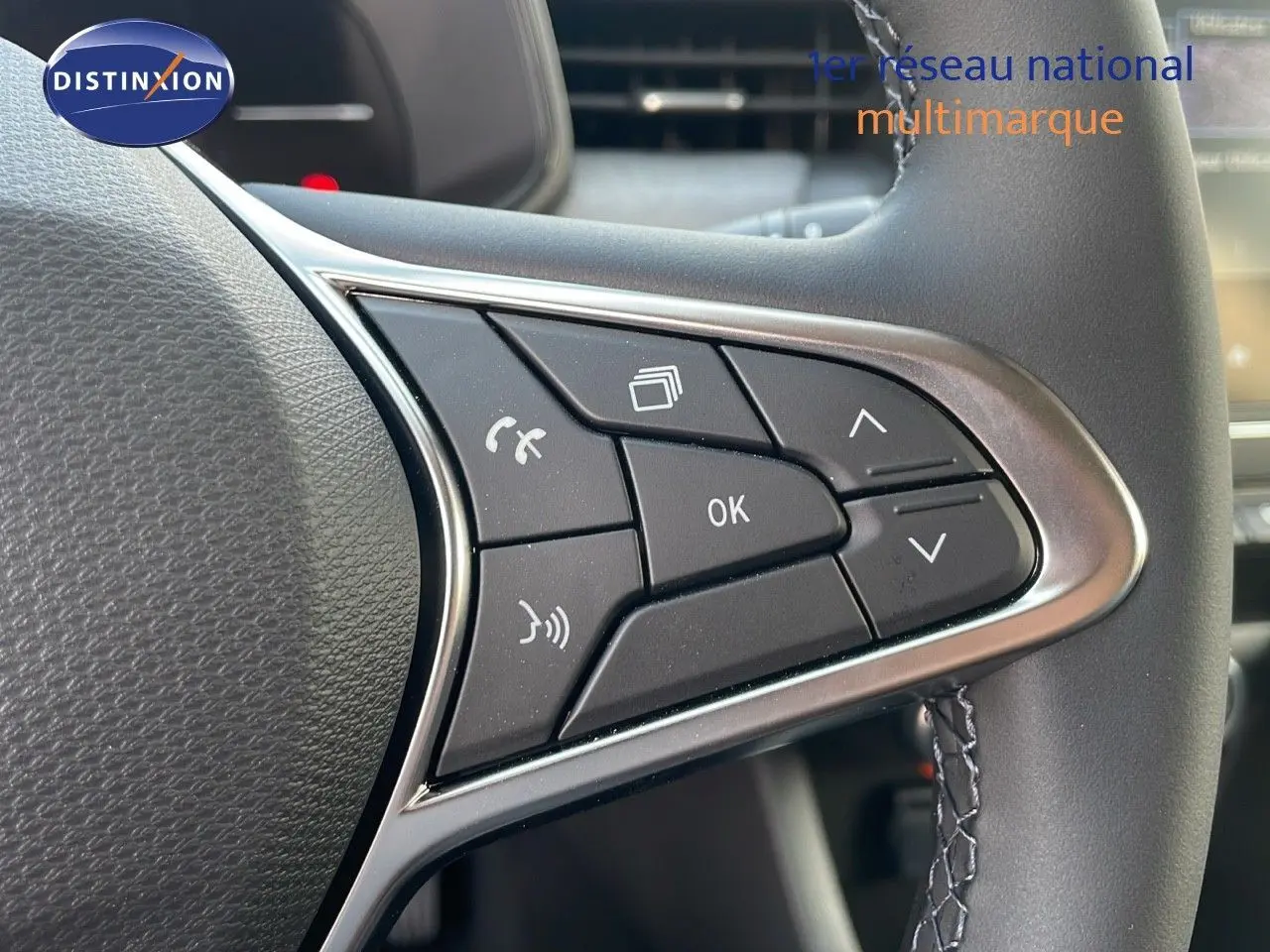 Gros plan sur les commandes au volant de la Renault Clio gris schiste métal, mettant en valeur les boutons multifonctions.