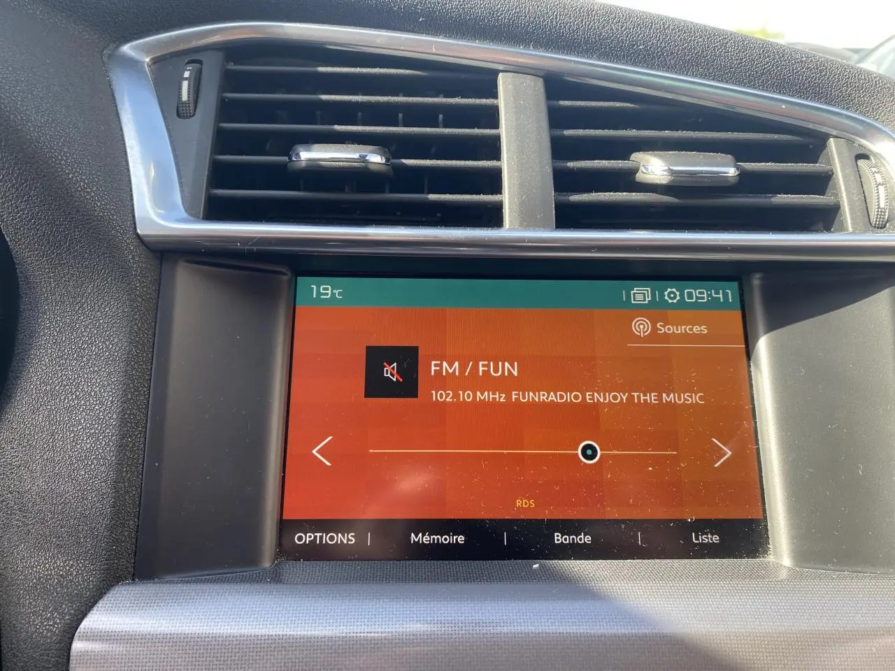 Écran tactile central de la Citroën C4 gris platinium 2017 affichant la radio FM vue de face.