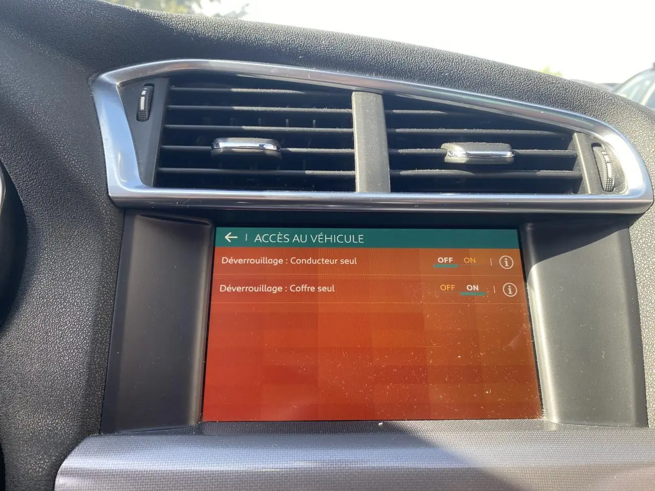 Écran tactile central de la Citroën C4 2017 montrant les options de déverrouillage, entouré de la console noire et grise.