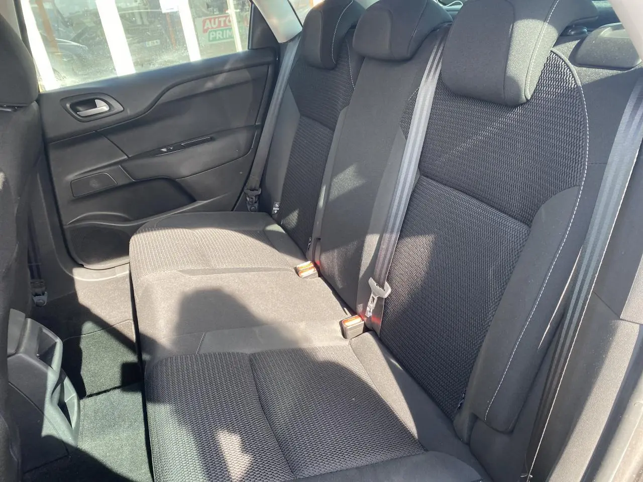 Banquette arrière vue côté droit de la Citroën C4 2017 avec sièges en tissu noir et ceintures grises.