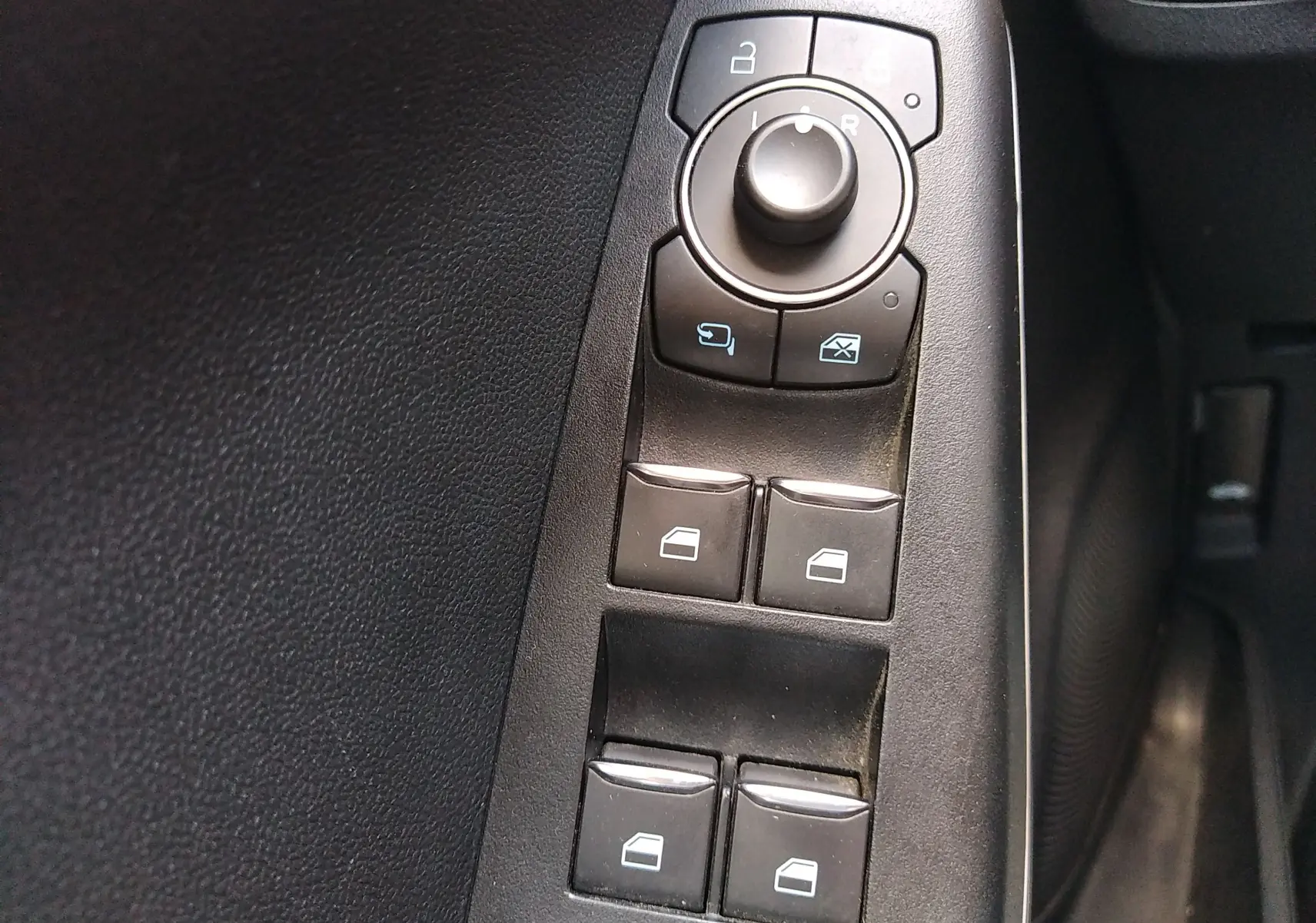 Panneau de commandes des vitres et rétroviseurs côté conducteur du Ford Puma blanc 2021, finition Titanium.