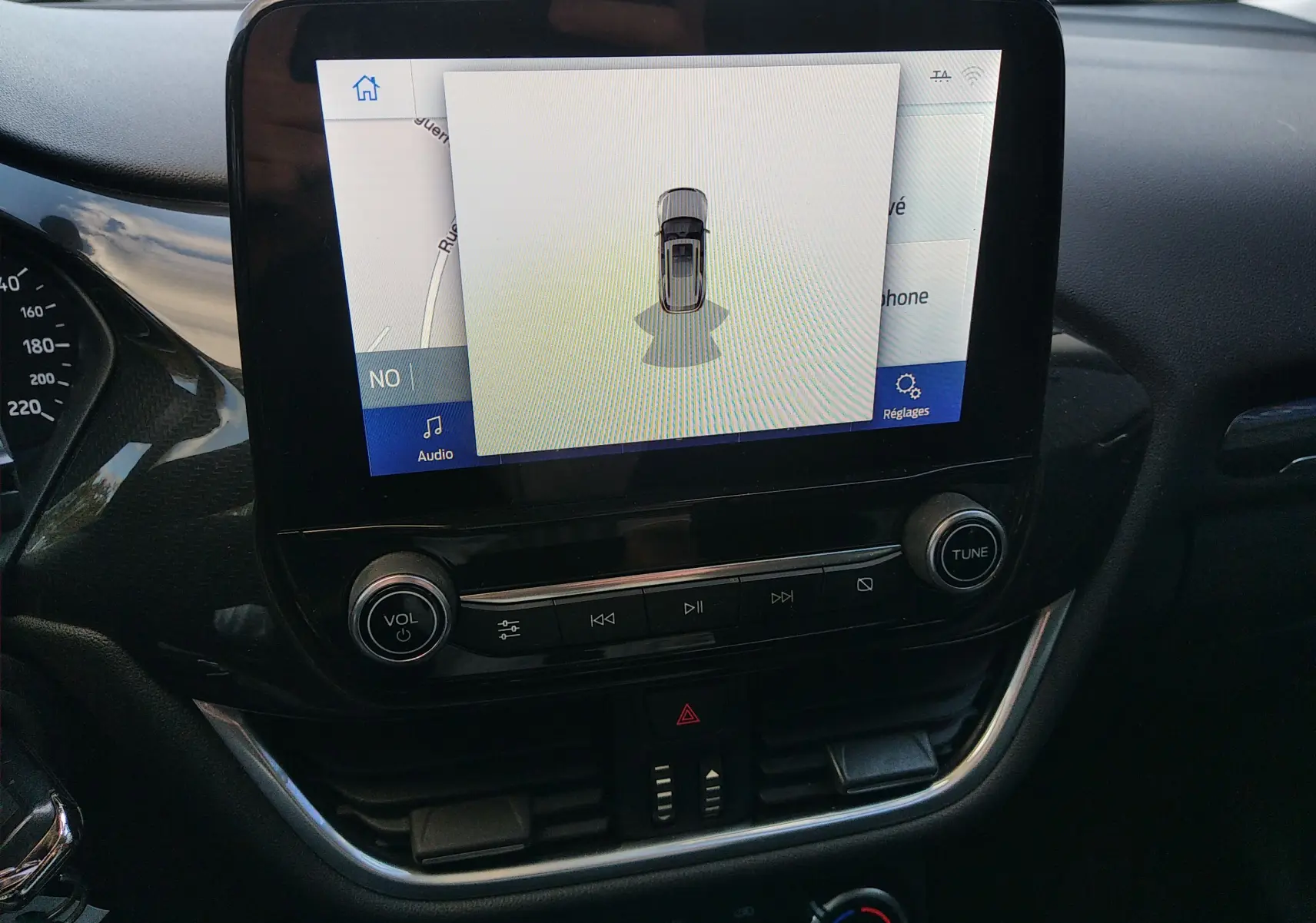 Écran tactile central du Ford Puma 2021 blanc montrant la caméra de recul avec commandes audio intégrées.