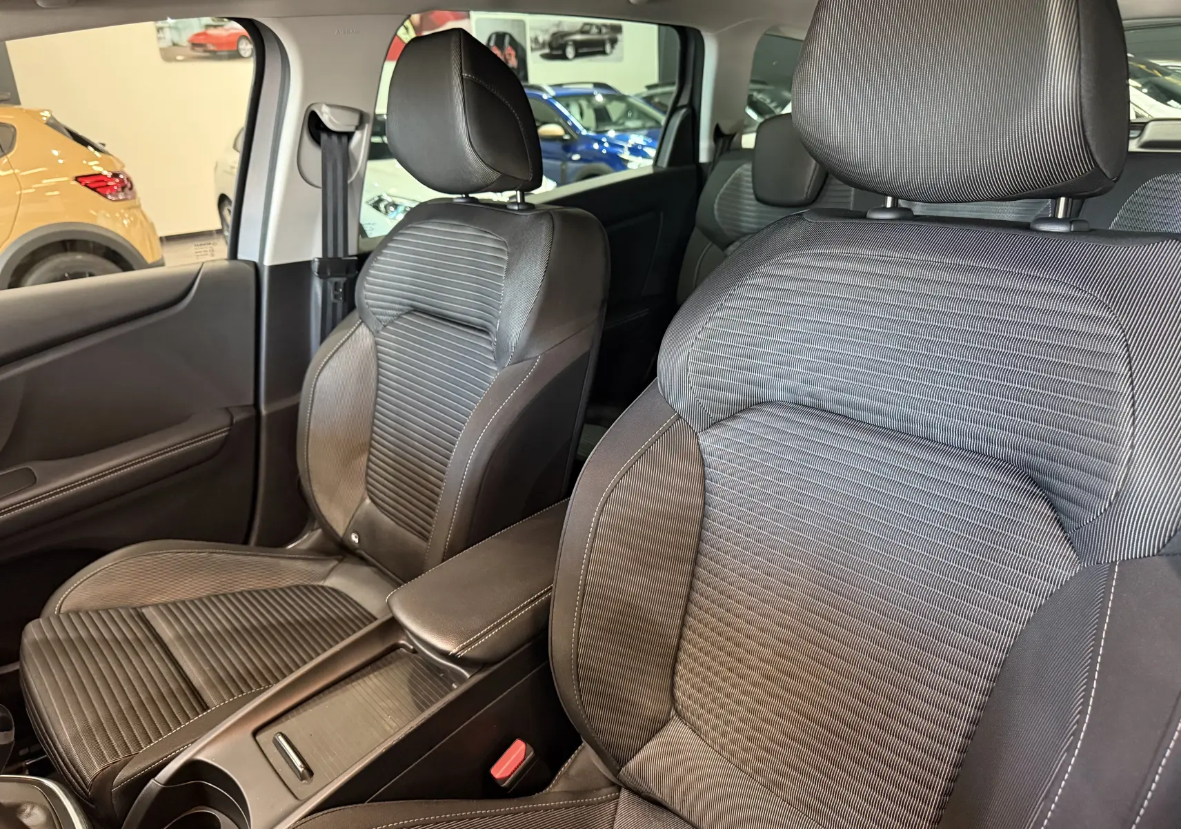 Gros plan sur les sièges avant en tissu gris du Renault Grand Scenic IV Business, intérieur spacieux et moderne visible.