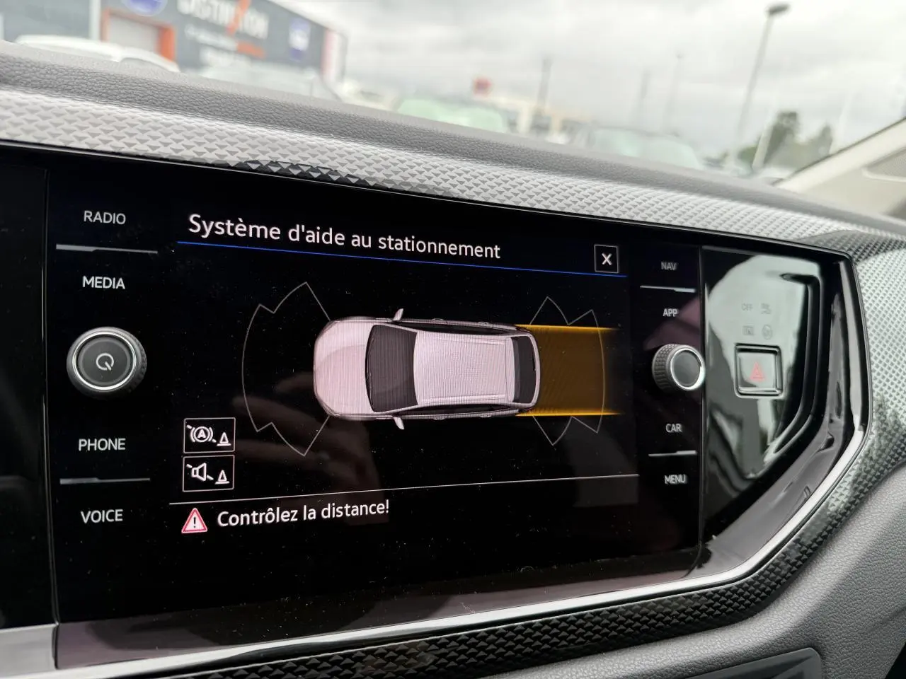 Vue rapprochée de l'écran tactile intérieur du Volkswagen Taigo 2024 affichant le système d'aide au stationnement.