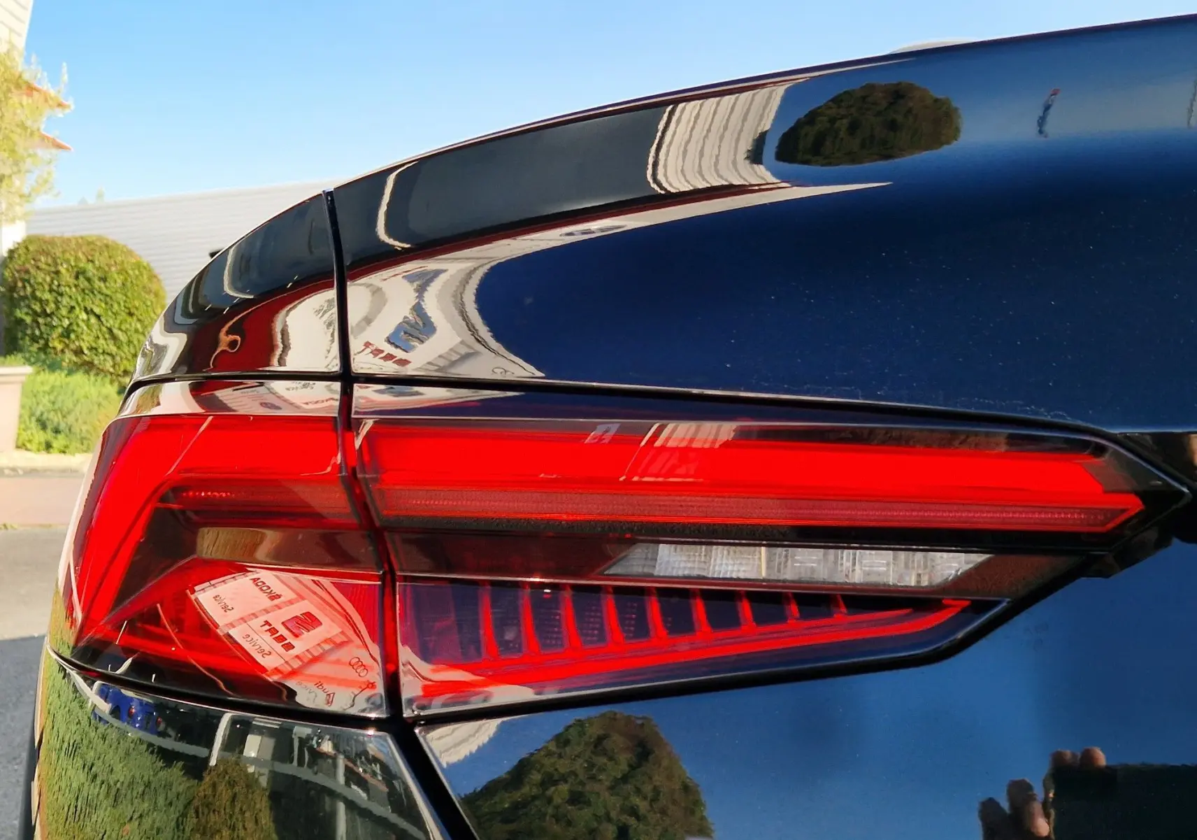 Gros plan sur le feu arrière droit rouge vif d'une Audi A5 Cabriolet noire brillante de 2017.