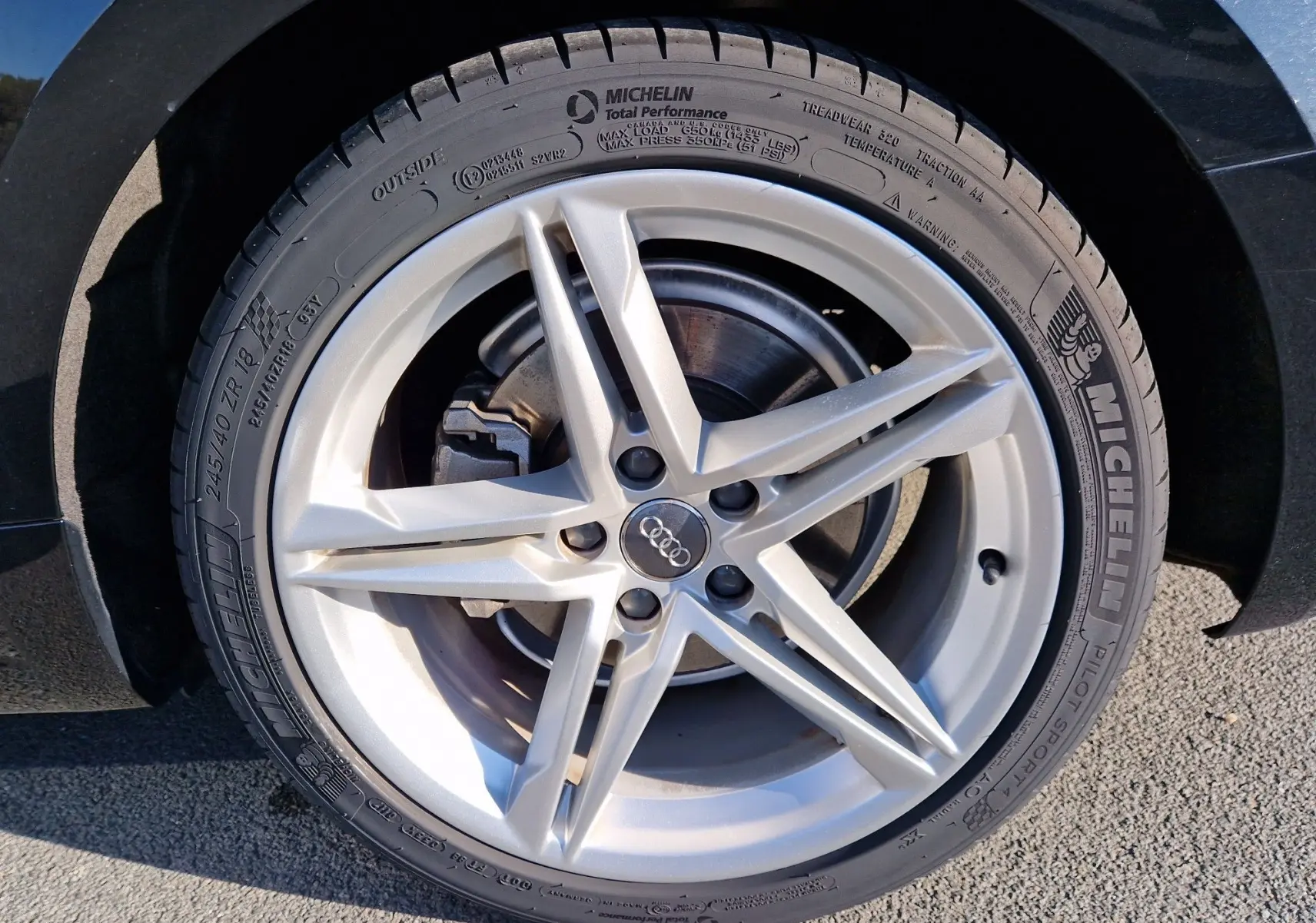 Gros plan sur la jante argentée à cinq branches de l'Audi A5 Cabriolet noire, mettant en valeur le pneu Michelin.
