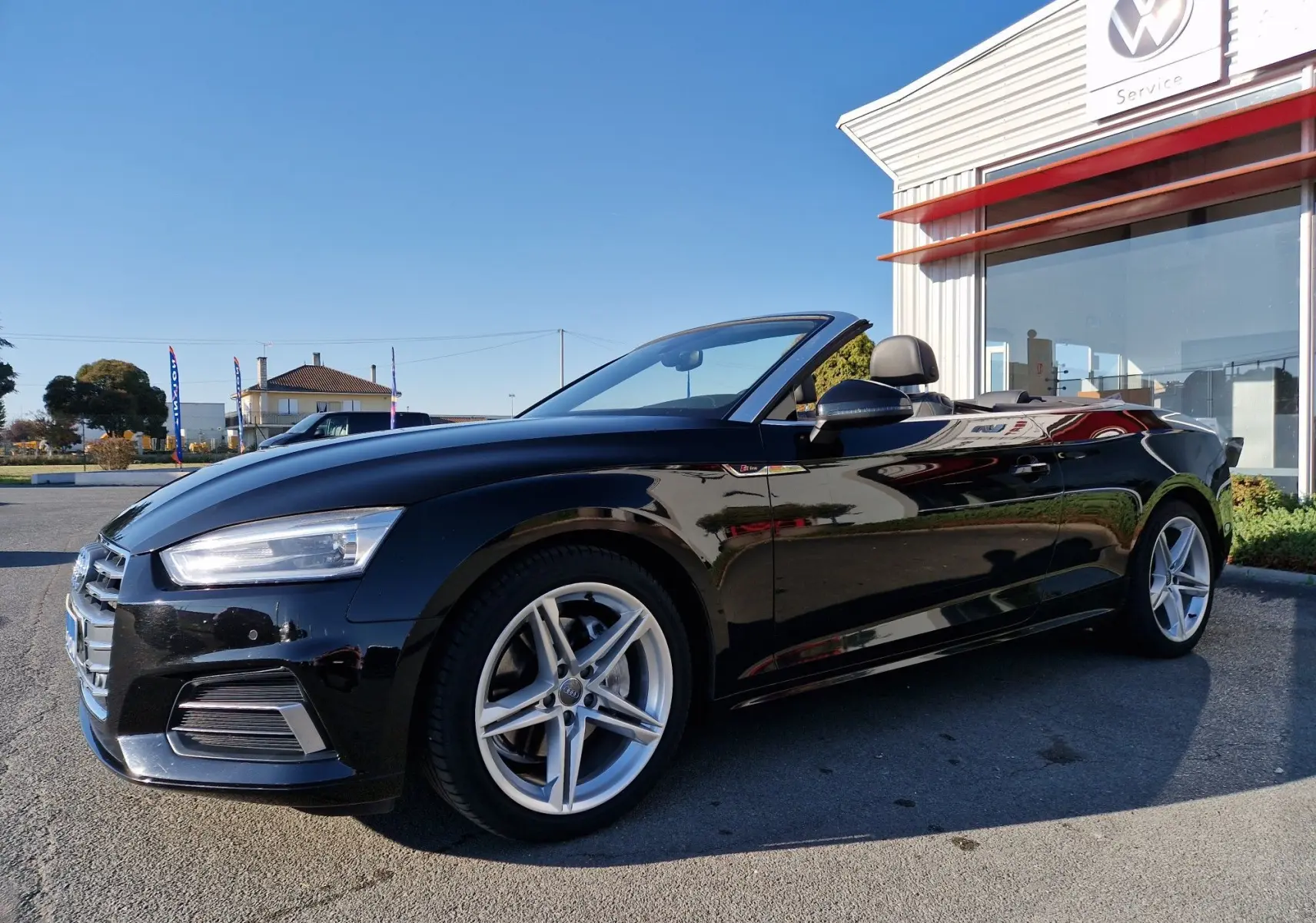 Audi A5 Cabriolet noir 2017 vue 3/4 avant droit, capote ouverte, jantes alliage et phares LED visibles