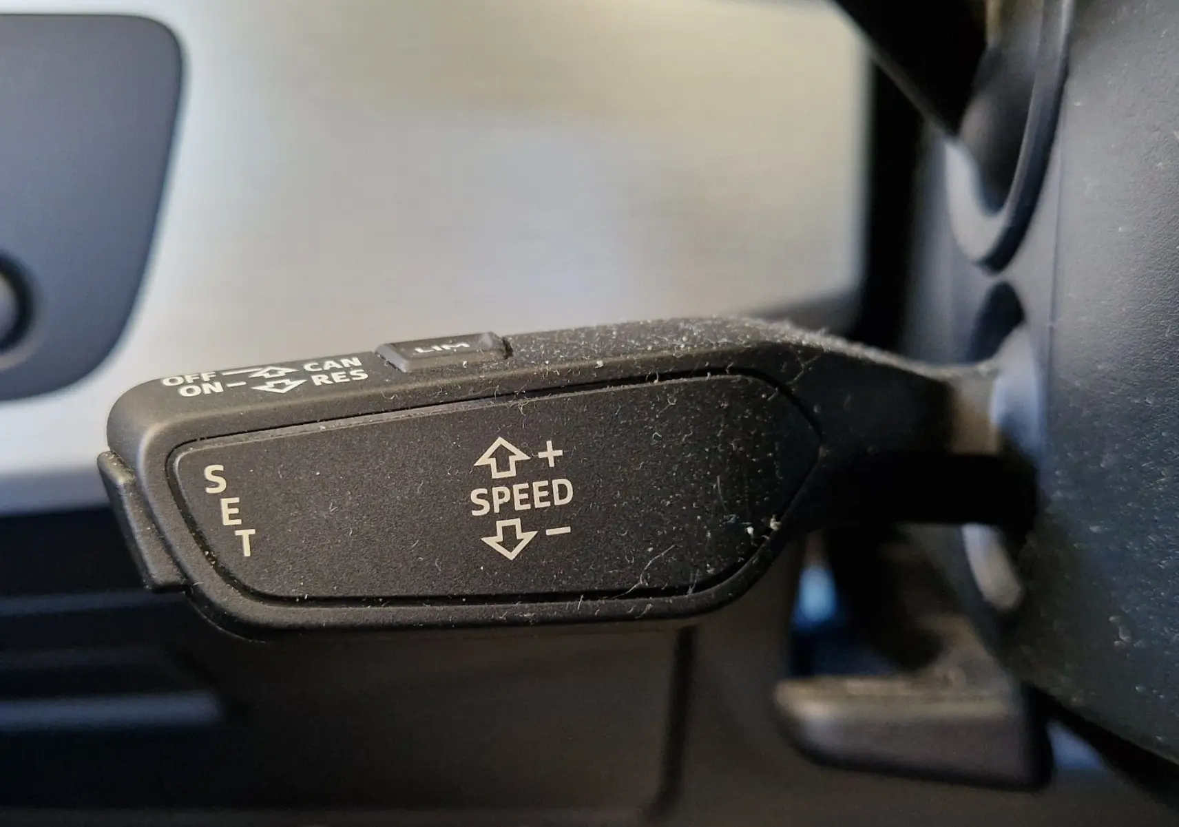 Gros plan sur la commande de régulateur de vitesse noire à gauche du volant de l'Audi A5 Cabriolet noir de 2017.