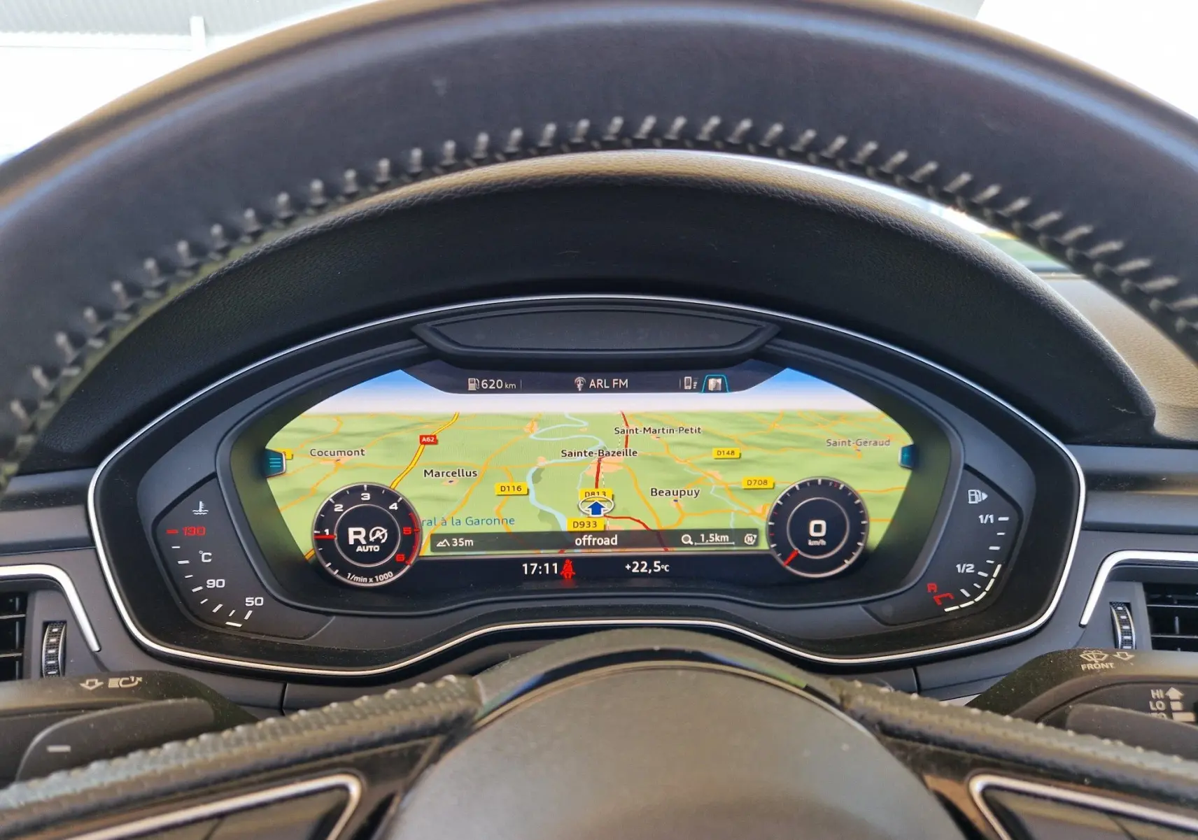 Tableau de bord numérique de l'Audi A5 Cabriolet noir, affichant la navigation et les compteurs vus depuis le volant.