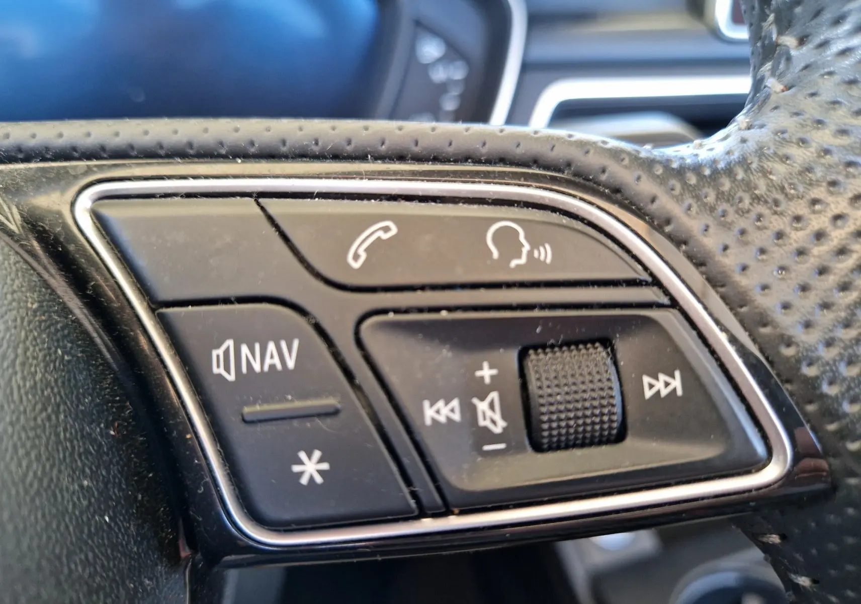 Gros plan sur les commandes multimédia au volant en cuir noir de l'Audi A5 Cabriolet 2017 diesel.