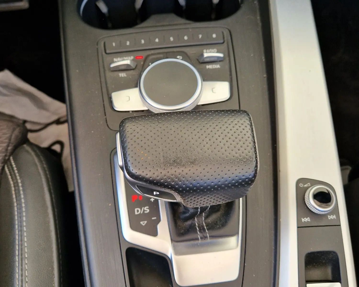 Vue rapprochée de la console centrale noire de l'Audi A5 Cabriolet 2017, mettant en valeur le levier de vitesse automatique en cuir perforé.