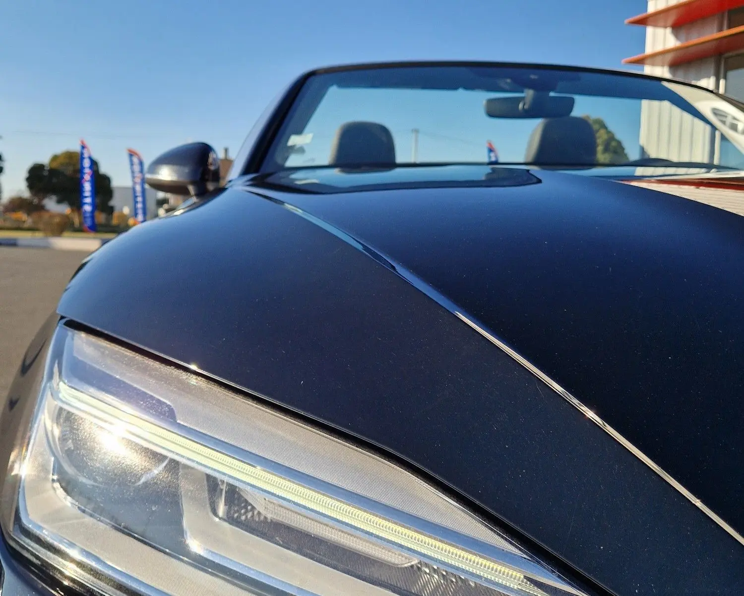 Gros plan sur le phare avant gauche d'une Audi A5 Cabriolet noire 2017, soulignant son design LED moderne.