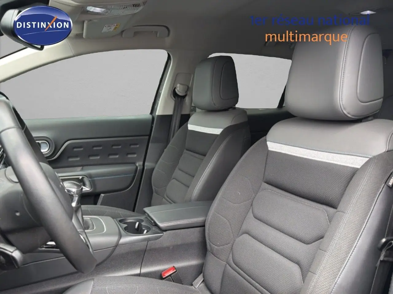 Vue intérieure côté conducteur du Citroën C5 Aircross 2022, sièges tissu gris avec bande claire et console centrale.