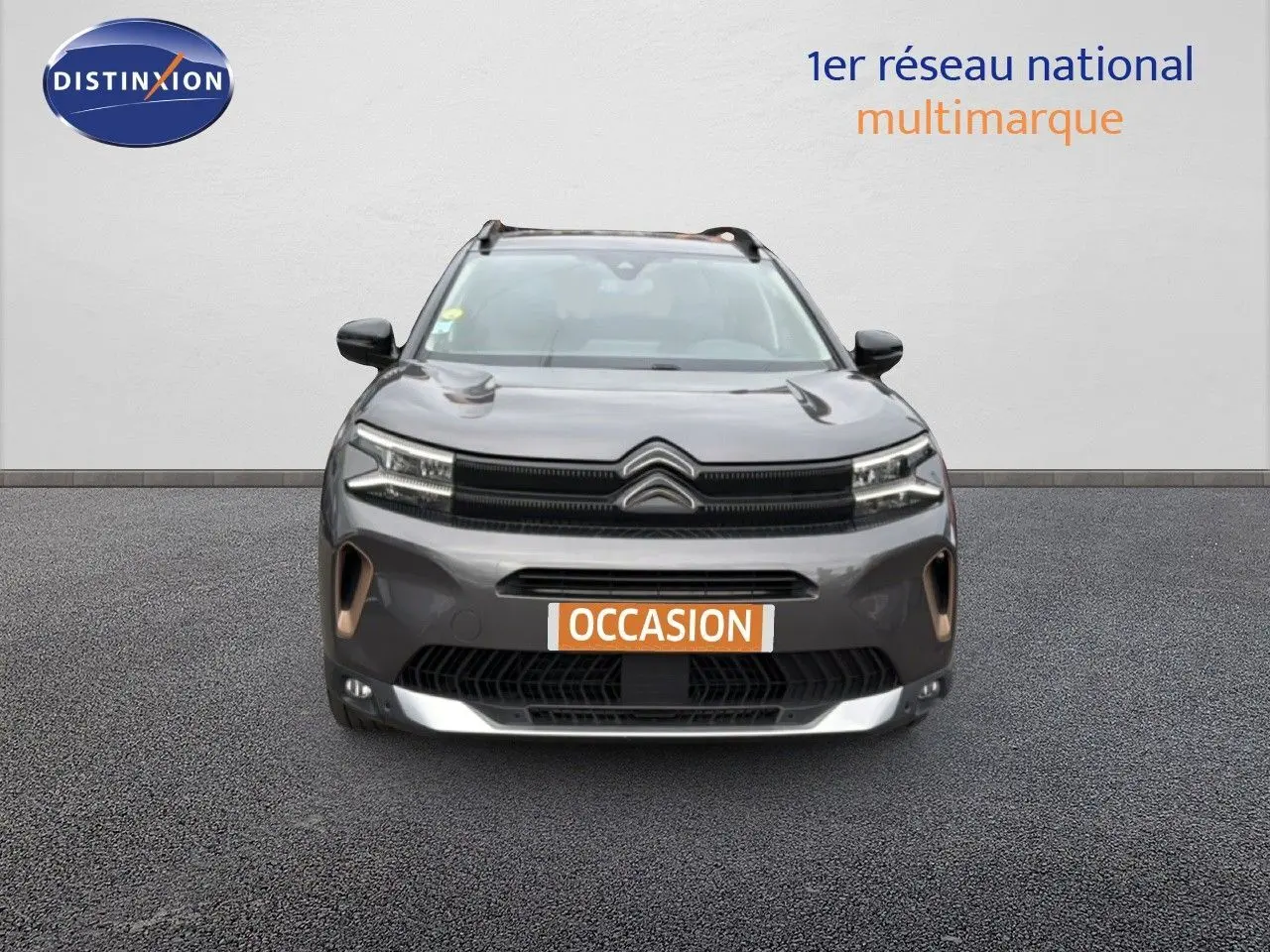 Vue de face du Citroën C5 Aircross gris platinium 2022 avec calandre distinctive et phares LED allumés.