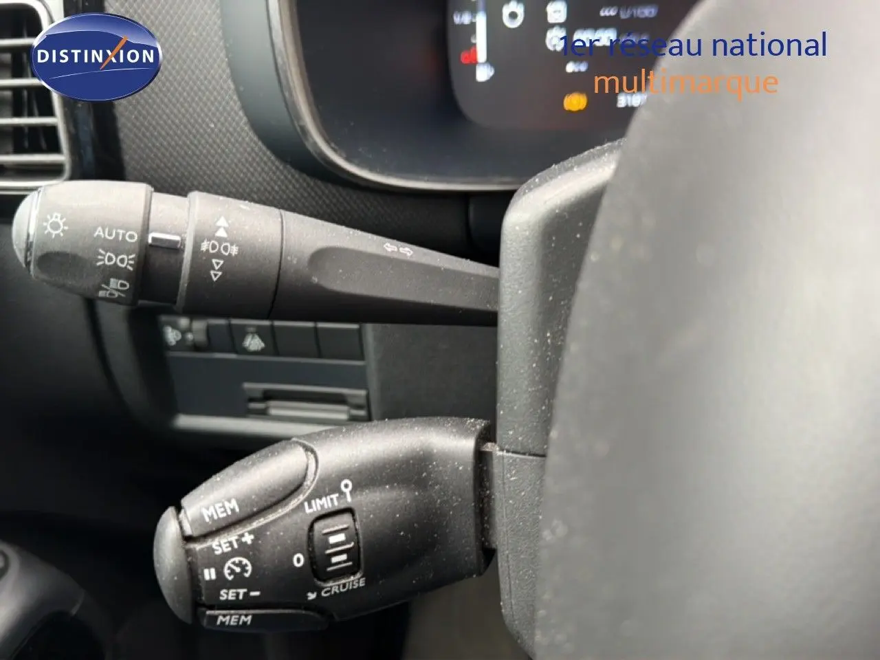 Gros plan sur les commandes au volant du Citroën C5 Aircross gris platinium, mettant en valeur les fonctions de régulateur et feux.
