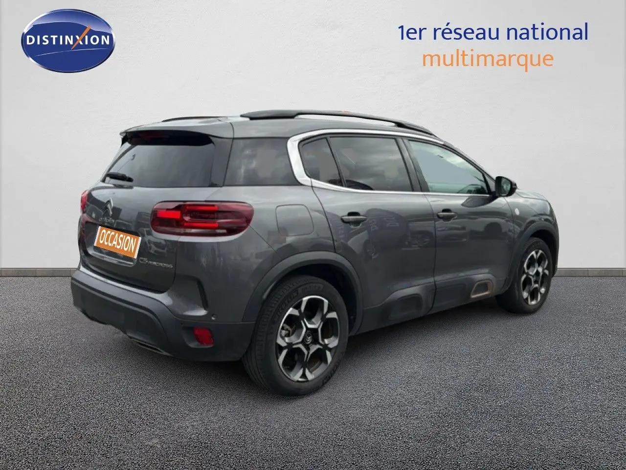 Vue 3/4 arrière droite d’un Citroën C5 Aircross gris platinium avec jantes bi-ton et vitres teintées.