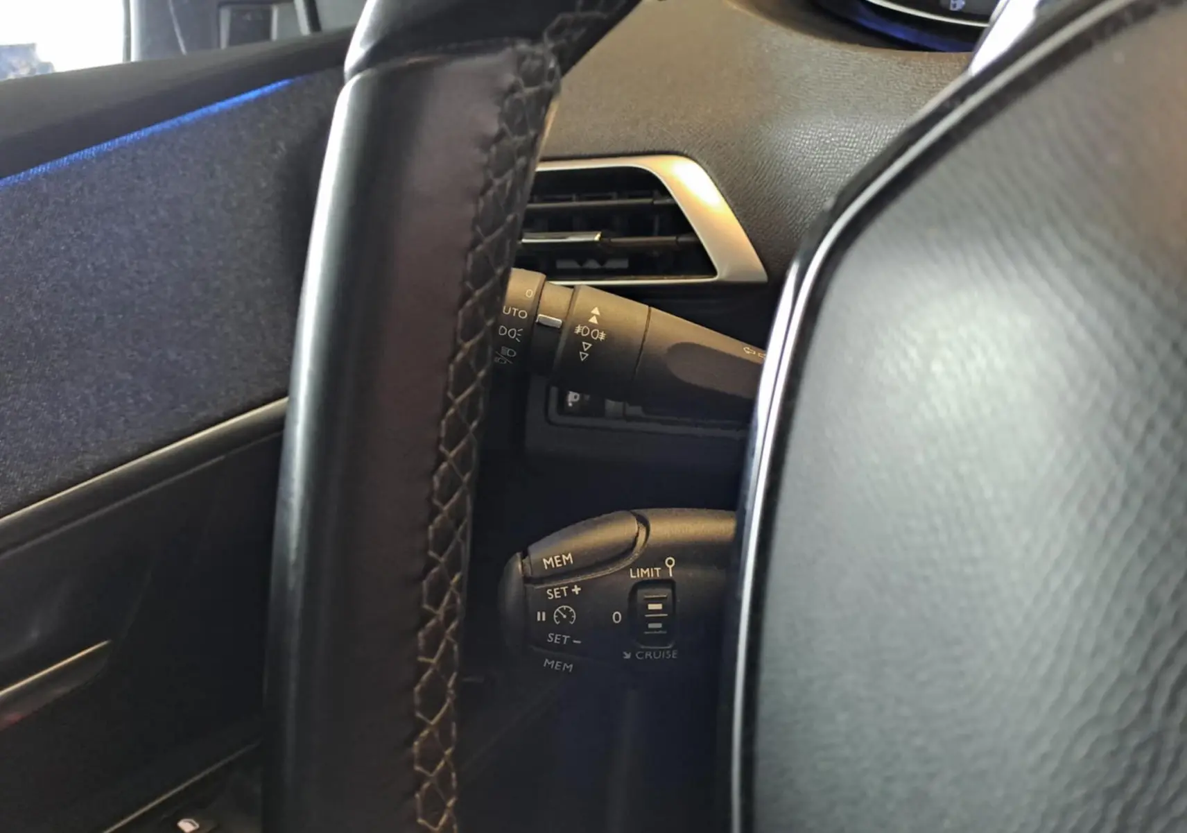 Détail du volant et commandes de régulateur de vitesse du Peugeot 3008 gris Artense, vue côté gauche intérieur.