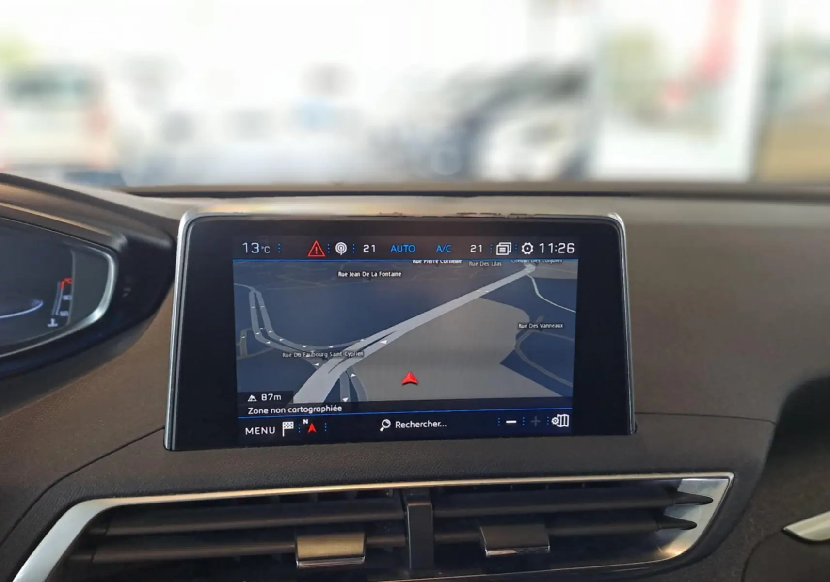 Écran central du système de navigation du Peugeot 3008 gris Artense, affichant une carte routière en intérieur.