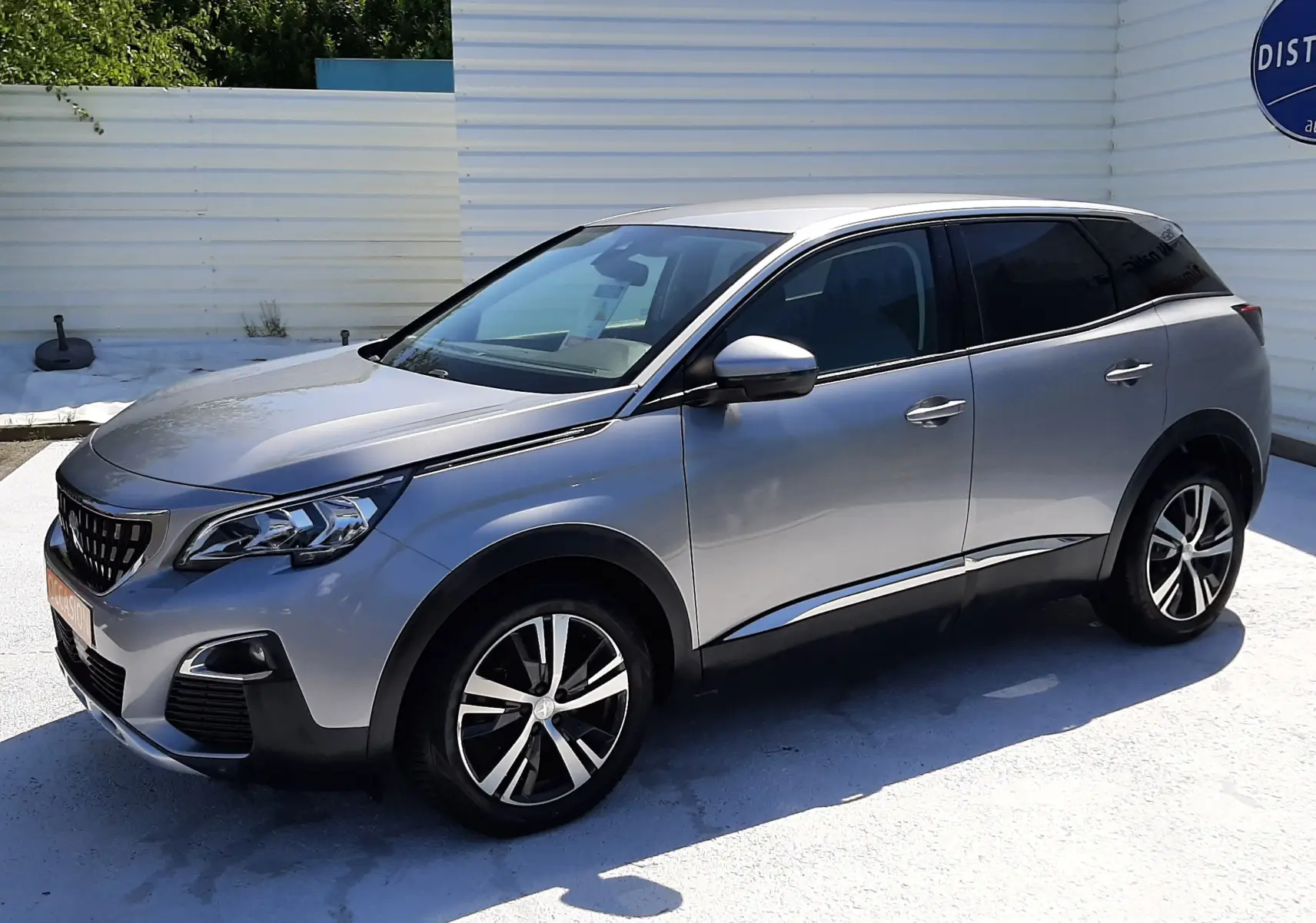 Peugeot 3008 gris Artense vue 3/4 avant droit, avec jantes alliage bicolores et vitres teintées.